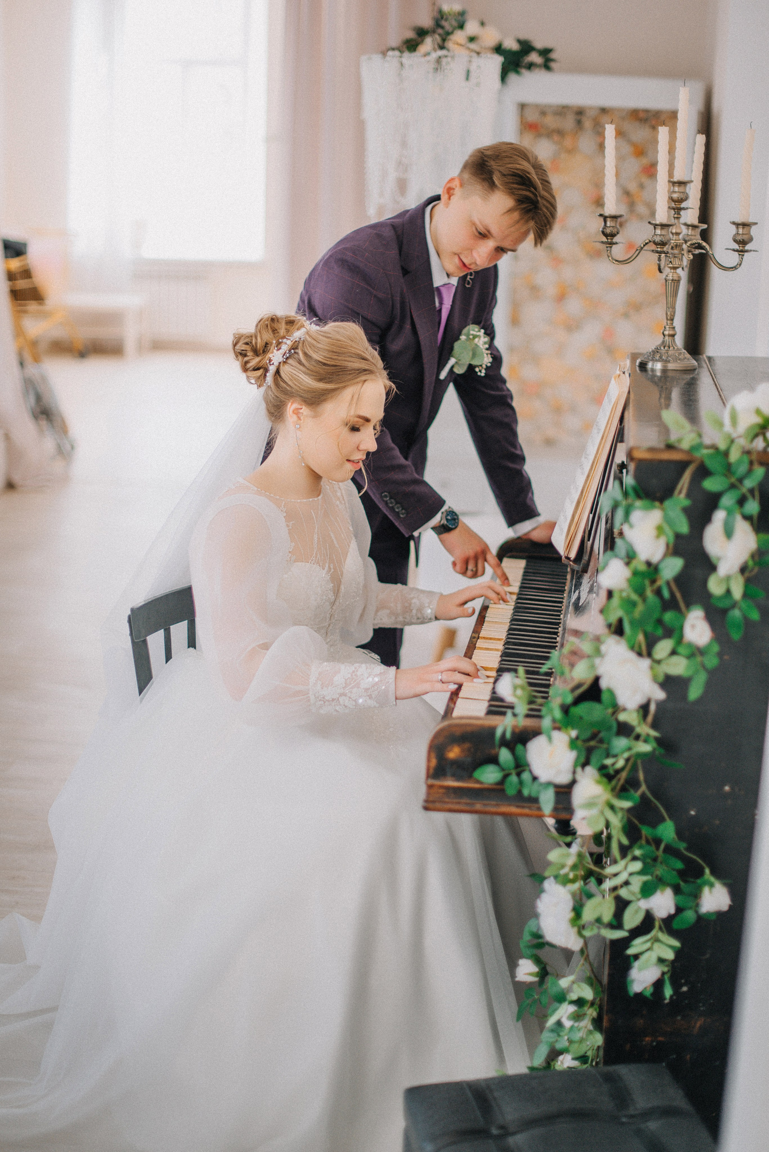пара играет на фортепиано в четыре руки на свадебной фотосессии