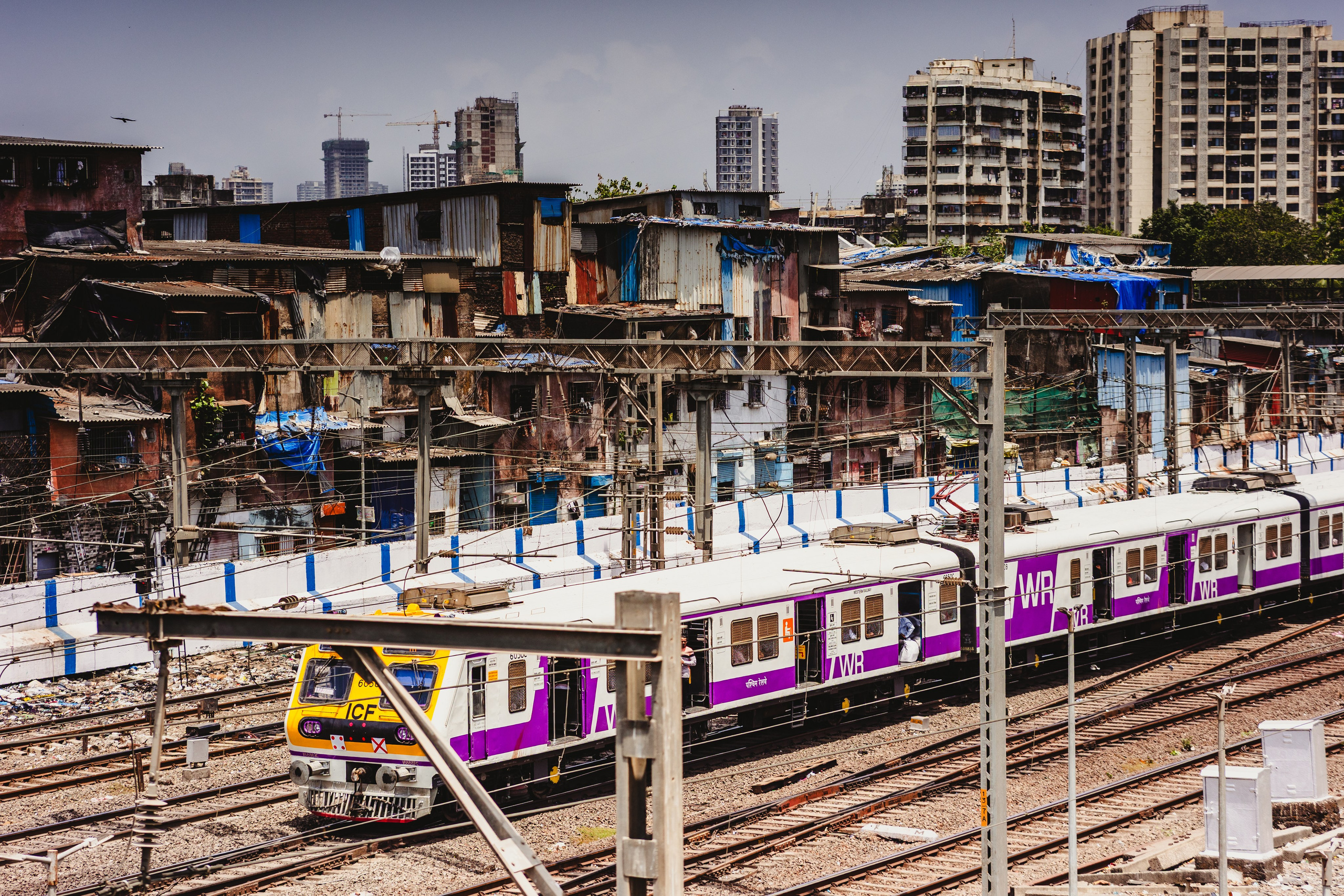 Электричка или метро на эстакаде в урбанистическом районе с трущобам