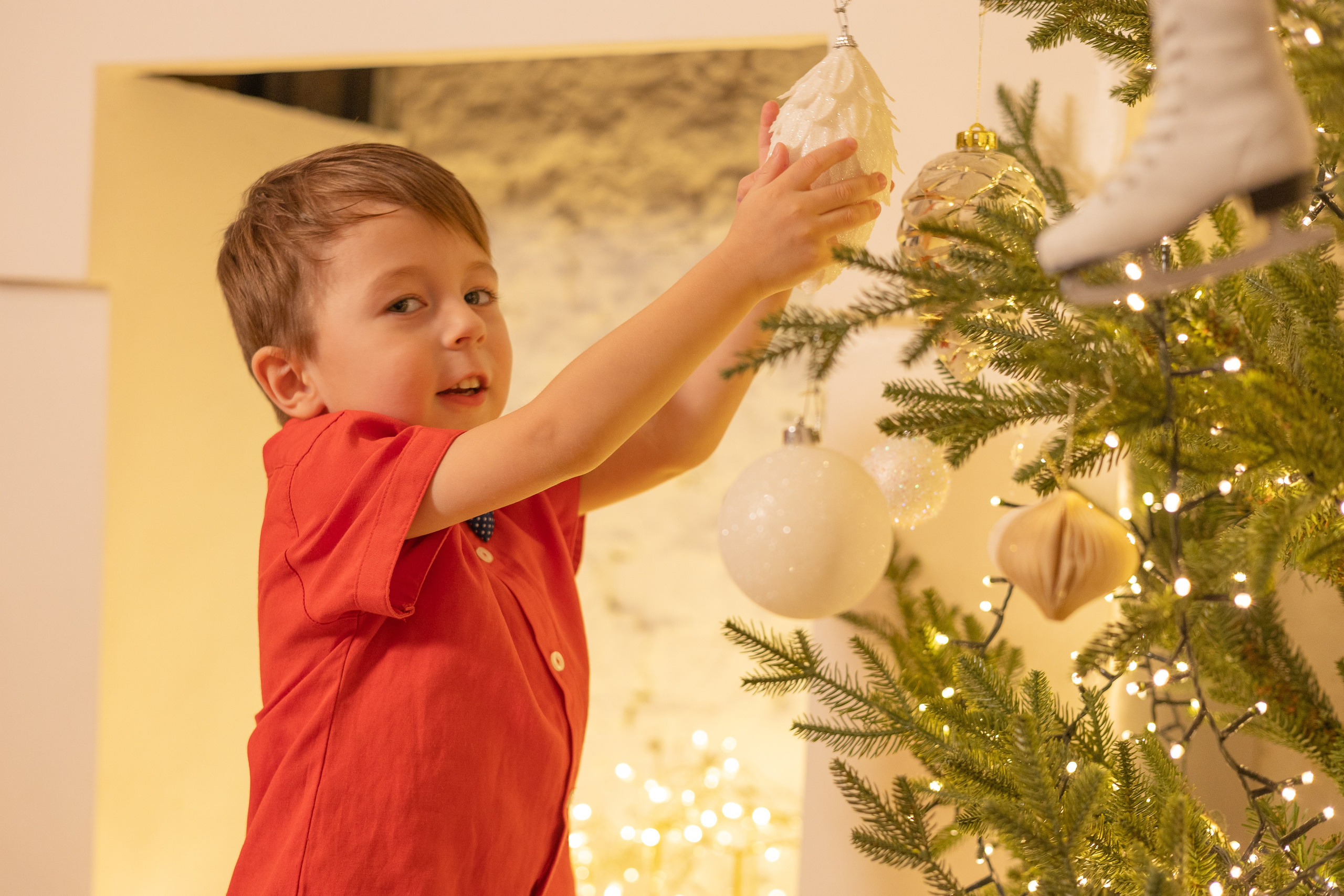 Мальчик разглядывает новогодние игрушки на елке