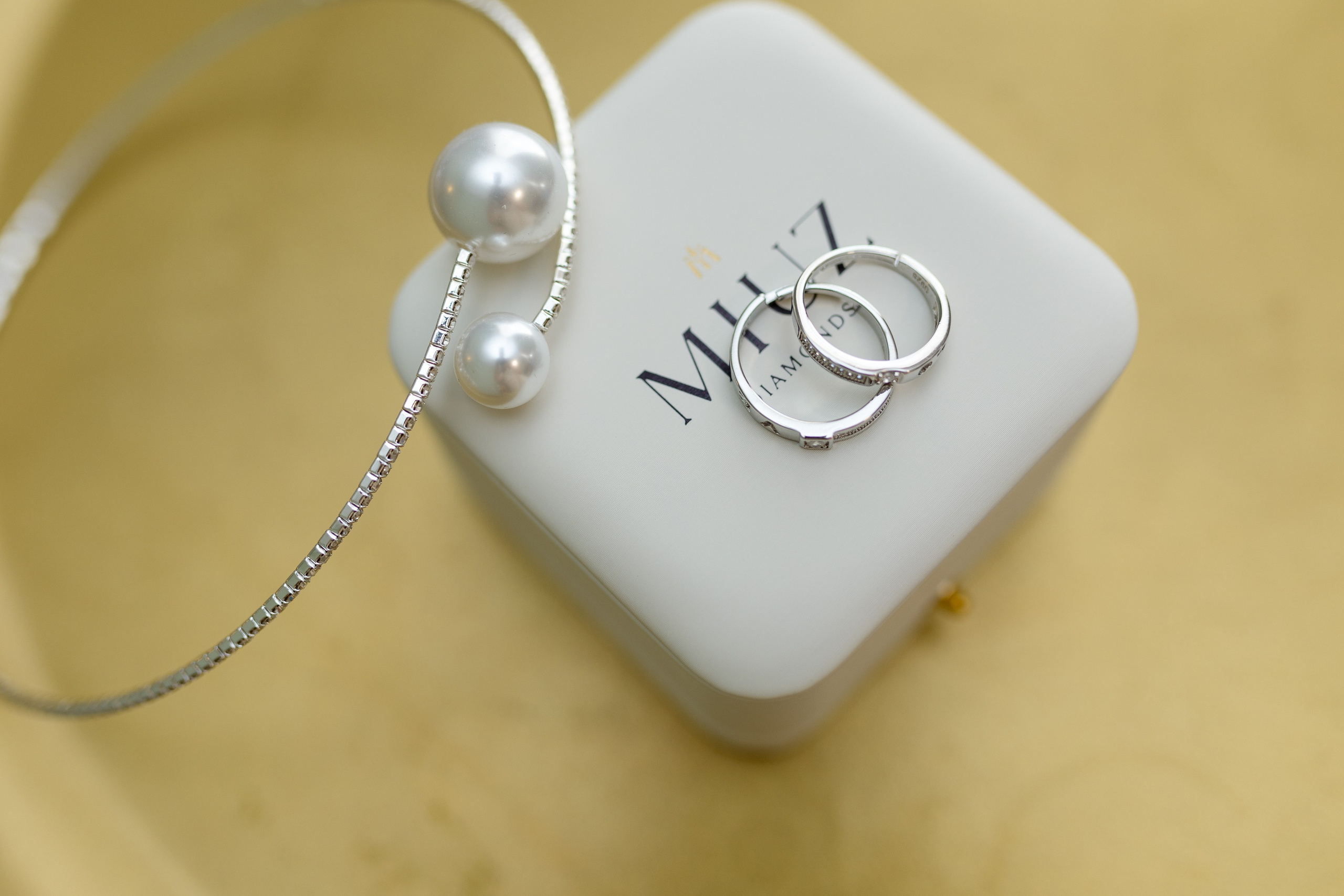 На белой коробочке лежат обручальные кольца.