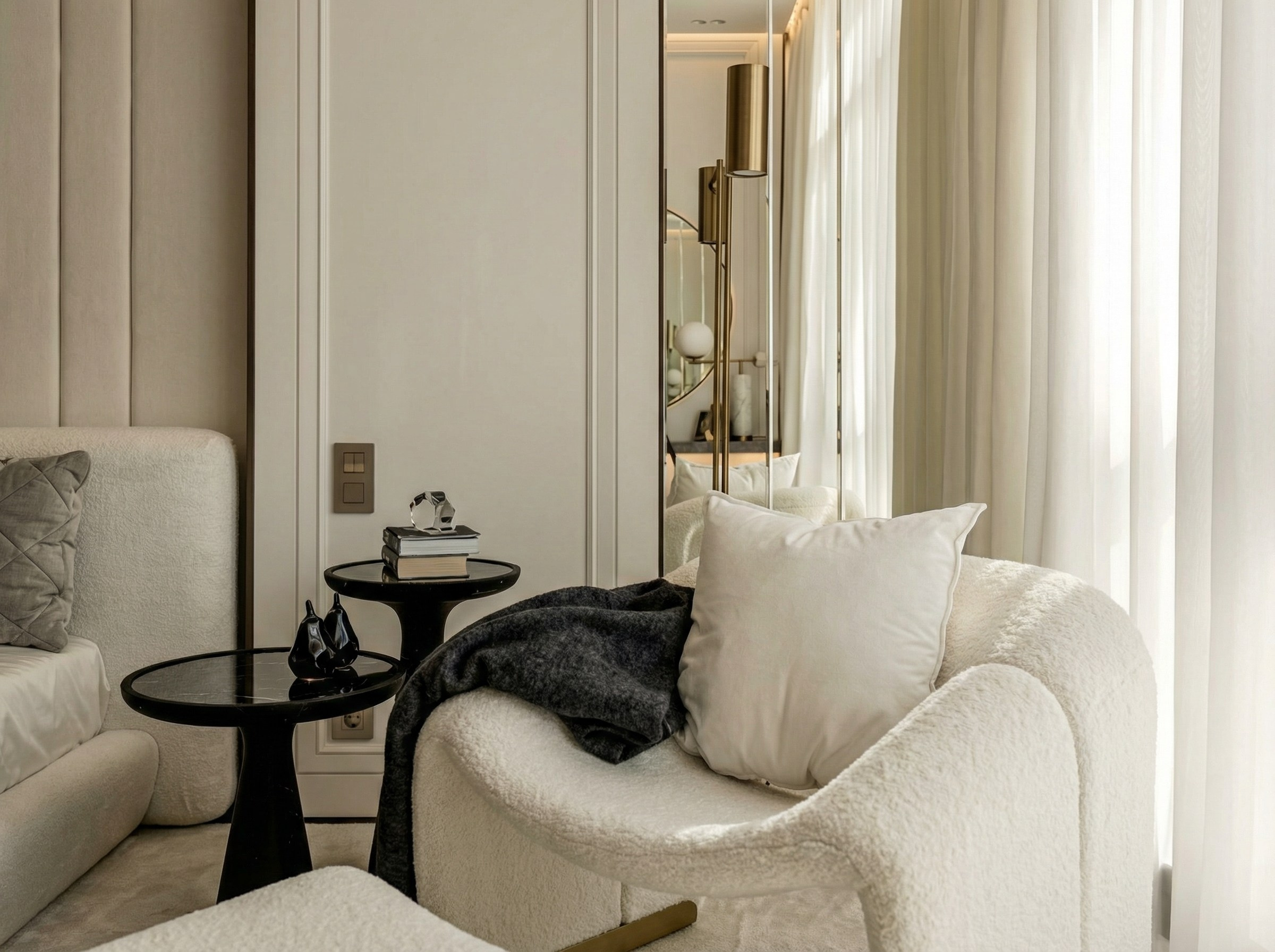 Зона отдыха в спальне квартиры 110 м² от Валерии Котович: кресло букле, зеркало в пол, пара черных кофейных столиков и латунный светильник в стиле тихой роскоши.