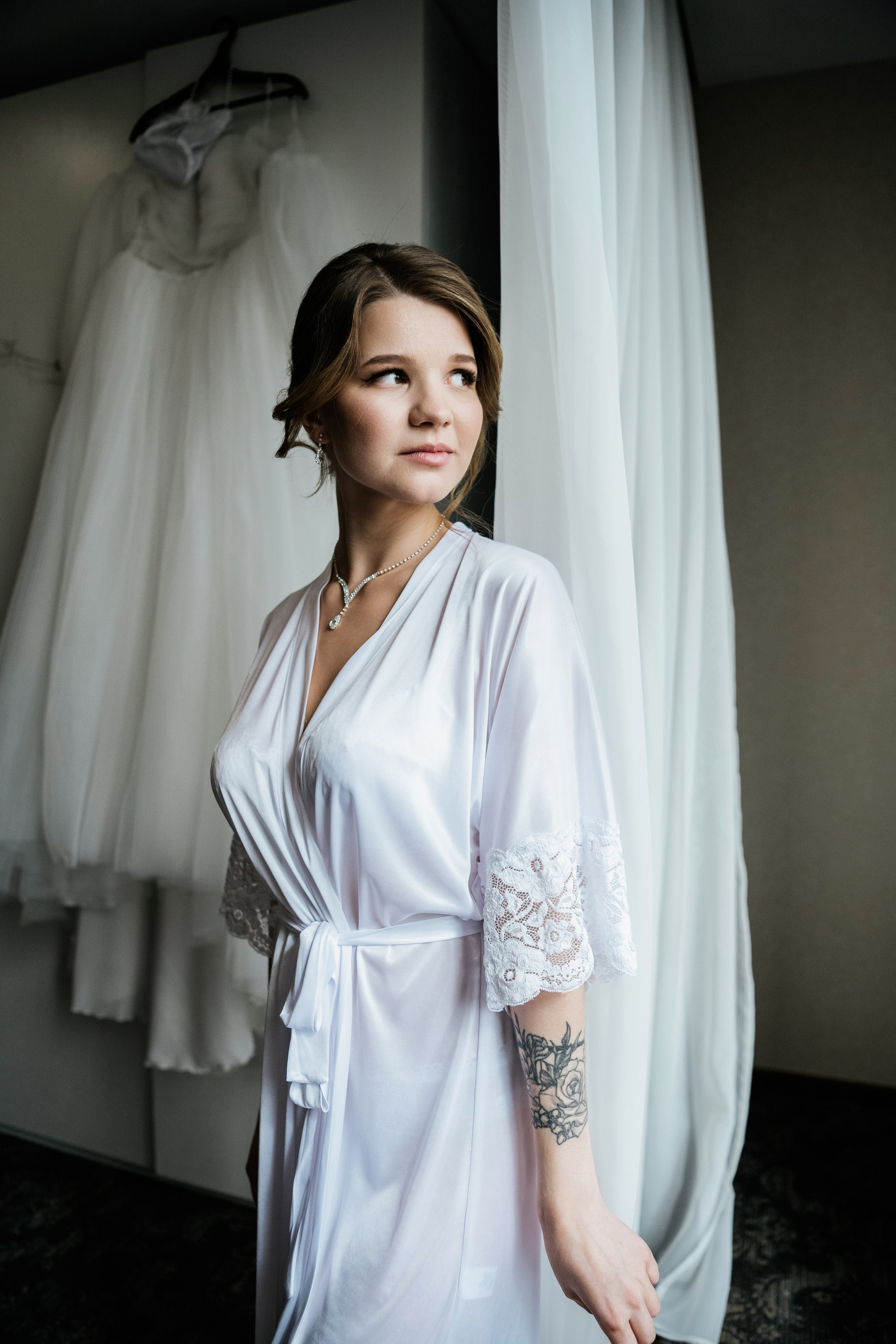 Взгляд невесты в сторону окна — мягкий свет и тишина