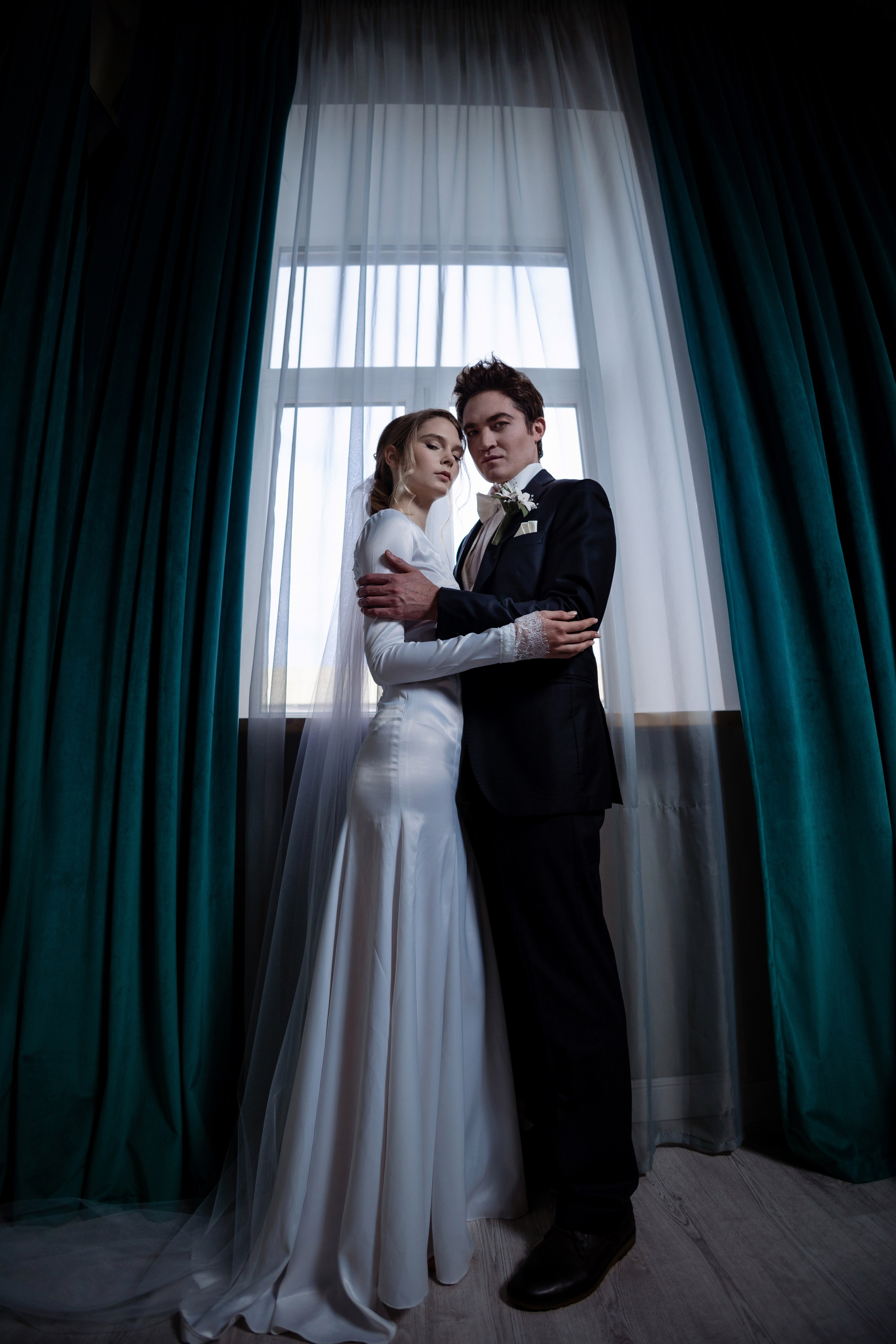 Жених и невеста в полный рост у окна,