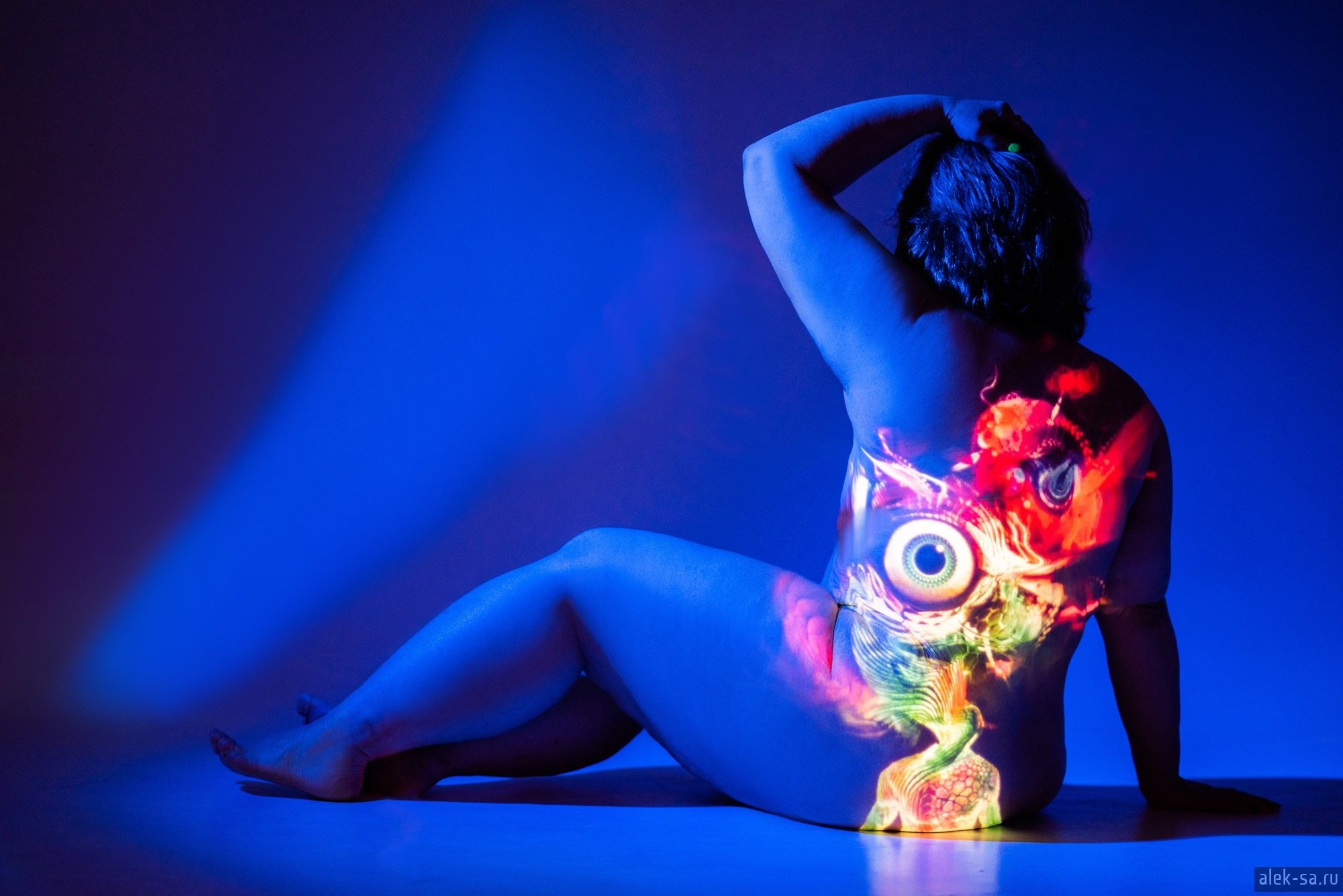 Арт-ню на синем фоне с проекцией рисунка на спине — фотограф Краснодар