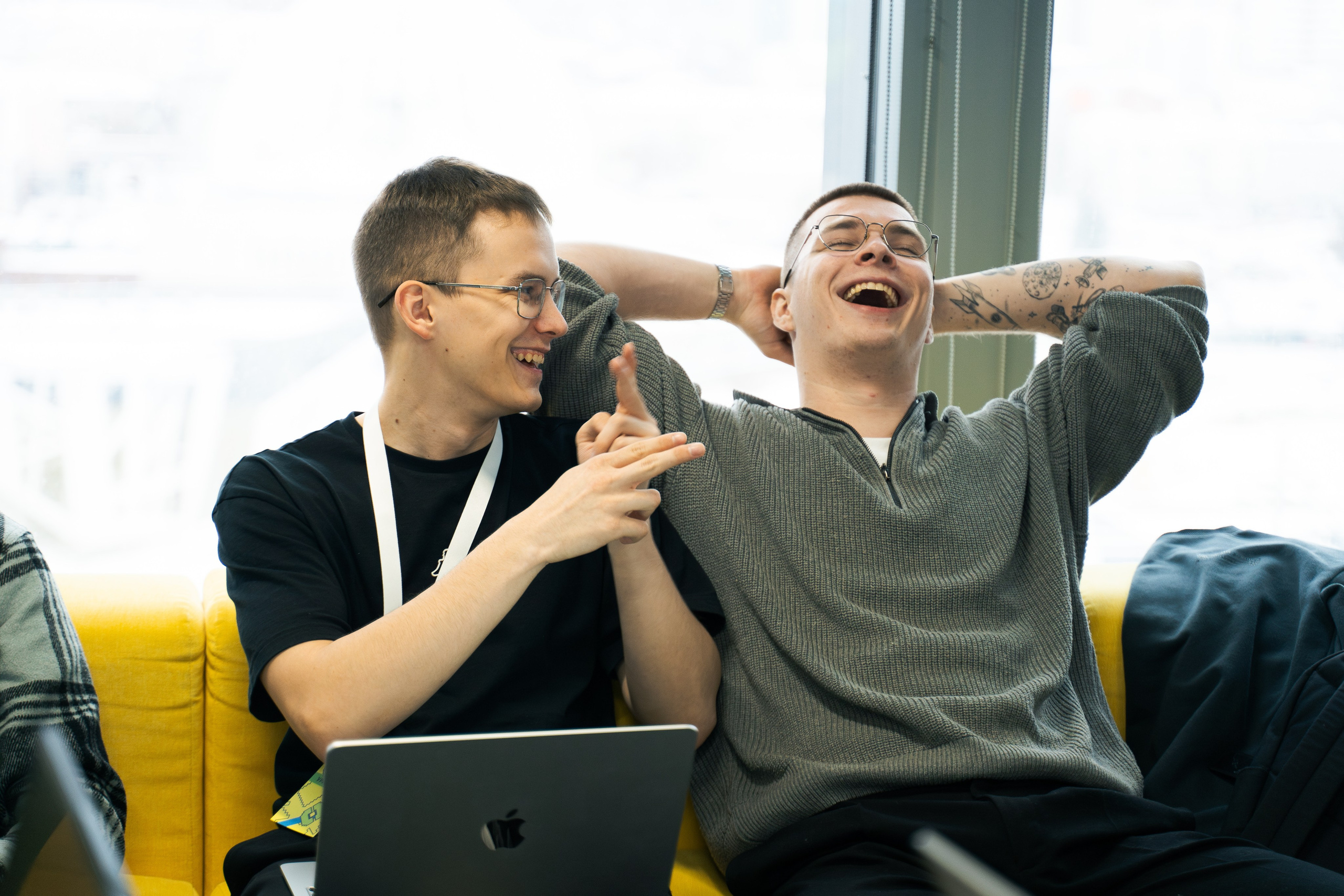 Команда разработчиков работает за ноутбуками и улыбается