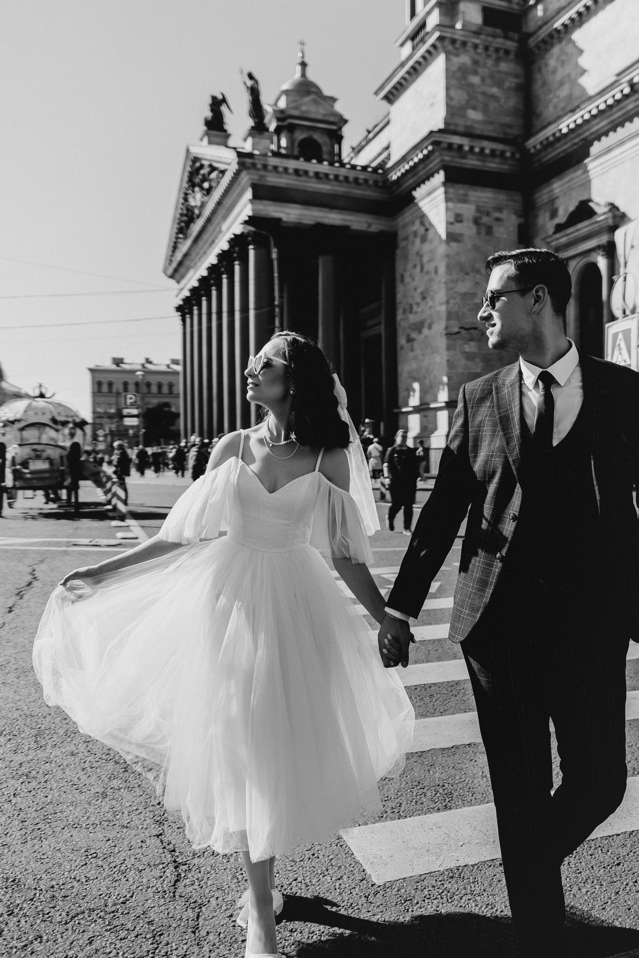 Черно-белая фотография с женихом и невестой которые идут по площади у Исаакиевского собора. Свадебная фотосессия у Исаакиевского собора.