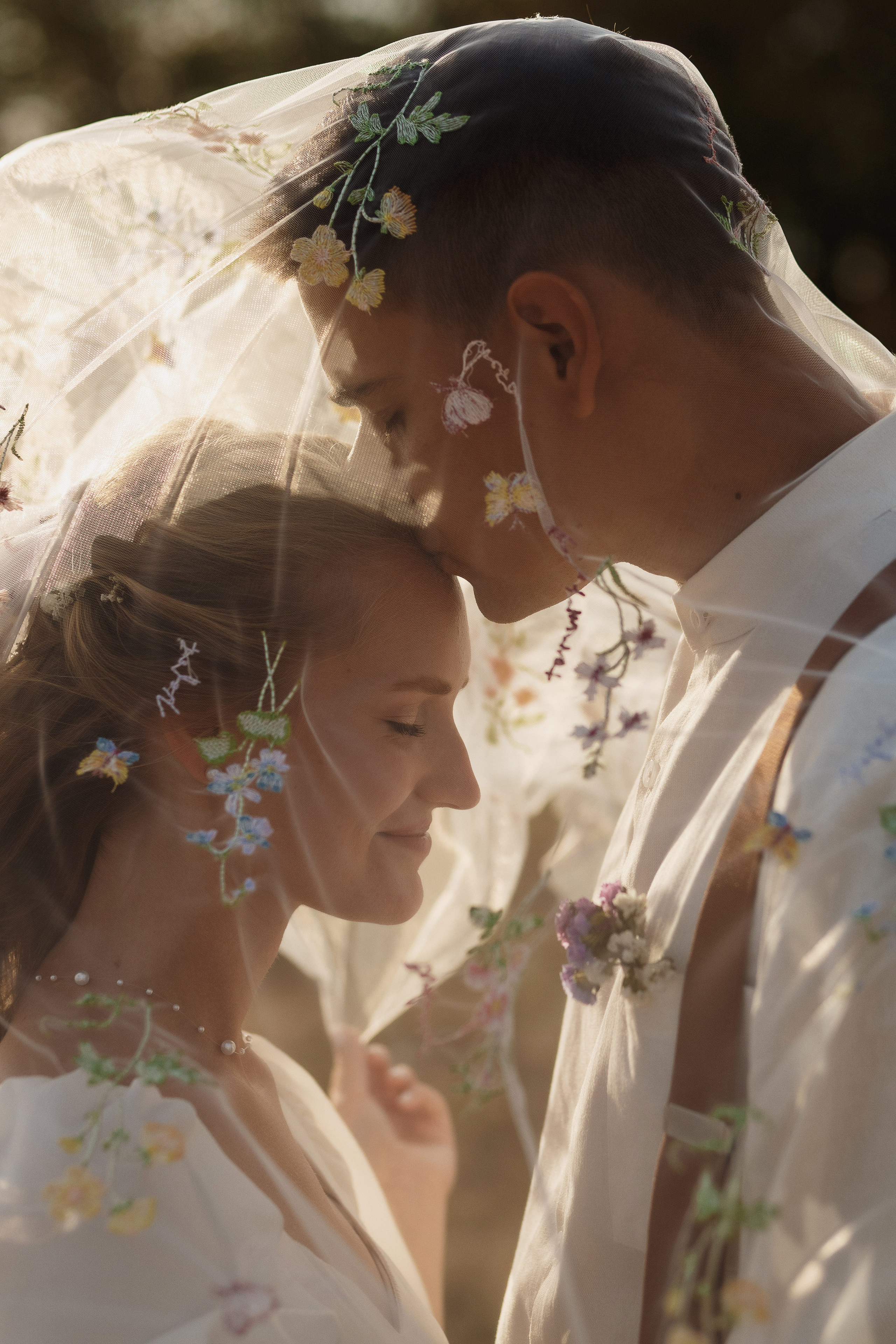 Жених целует невесту в лоб под фатой — утончённый момент любви, свадебная съёмка Таганрог.