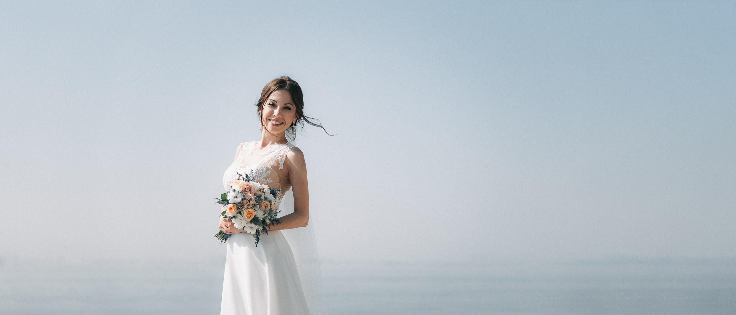 Фотография невесты в белом платье на фоне воды и неба Саратов