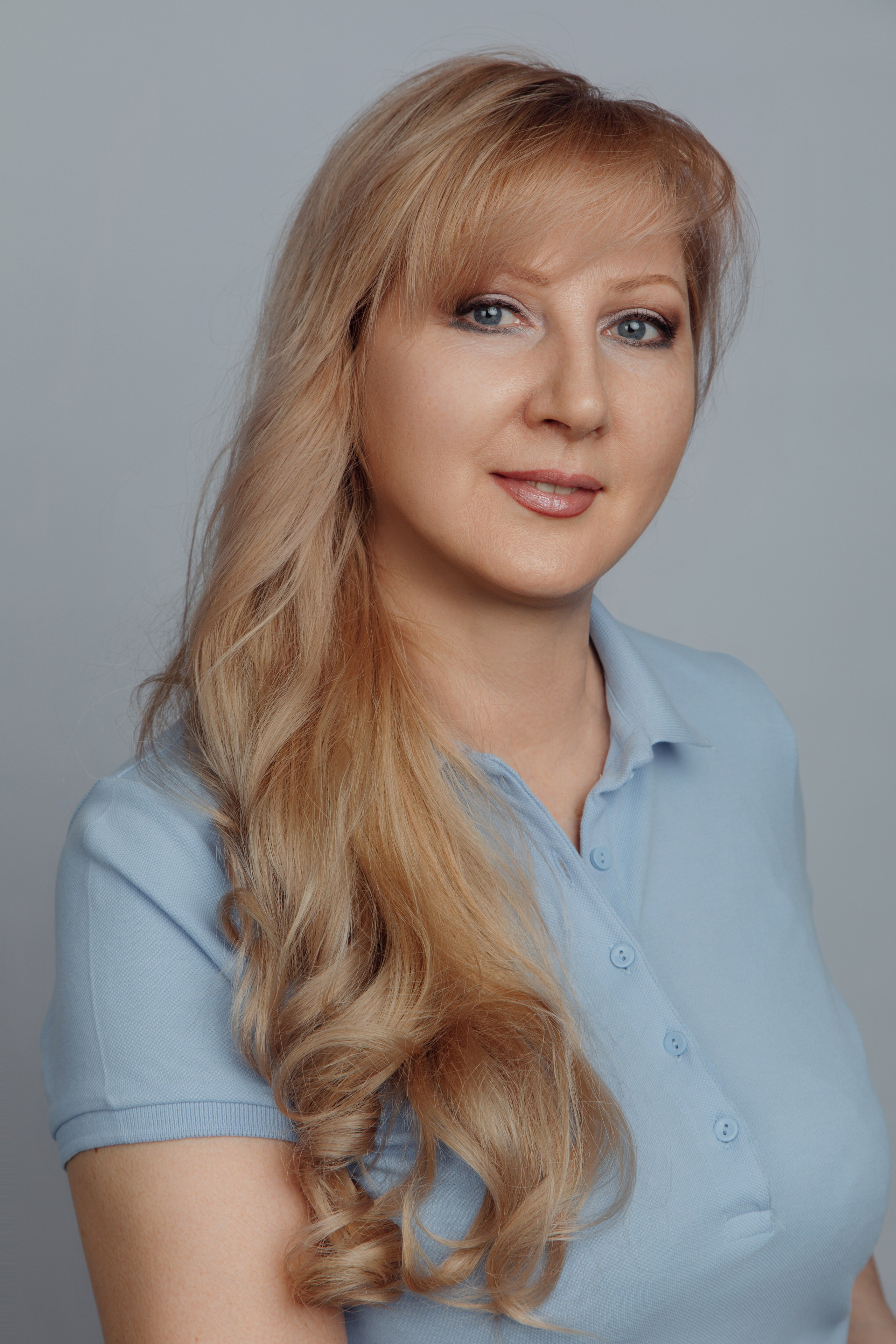 Доброжелательный портрет ассистента стоматолога на нейтральном фоне. Медперсонал клиники.