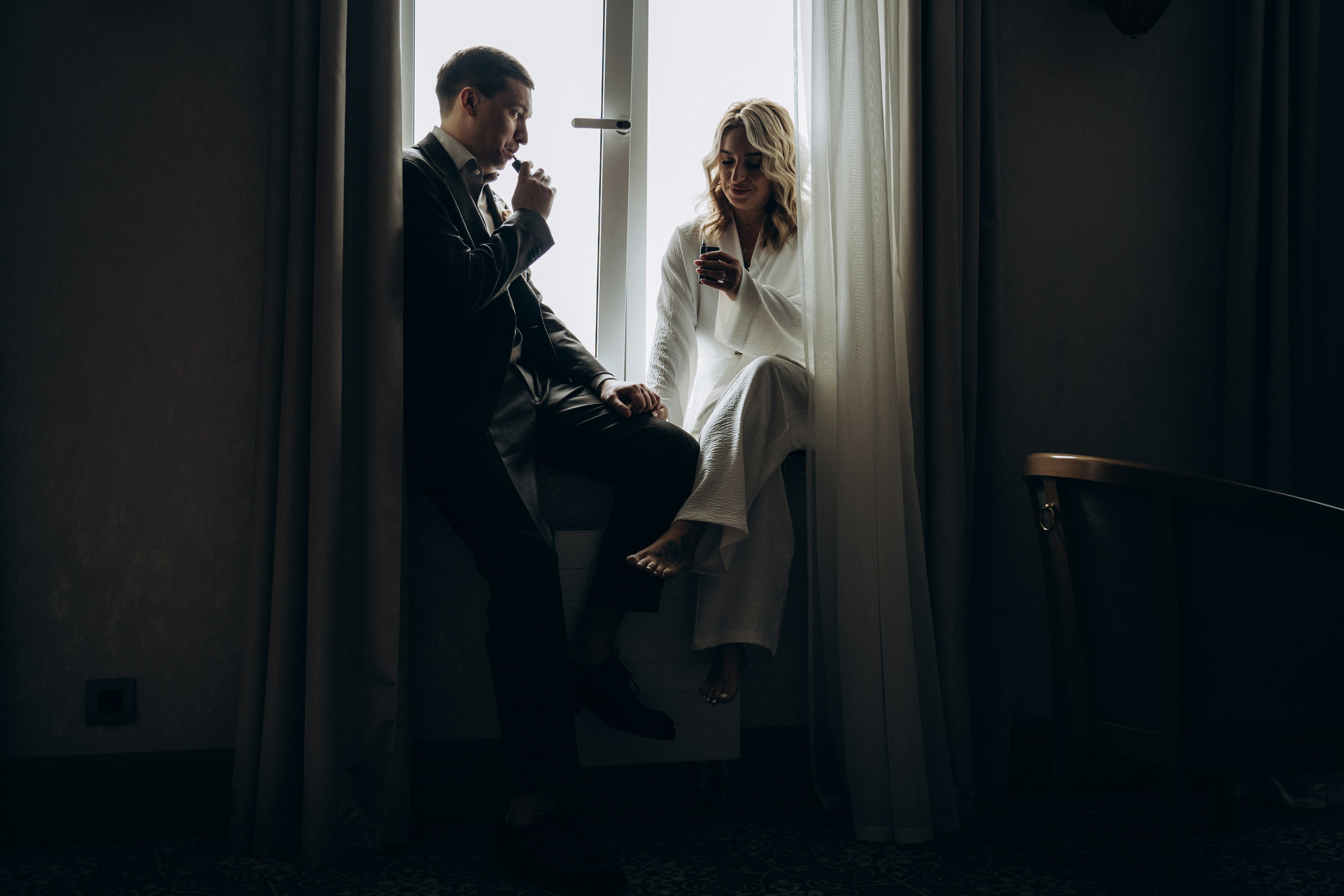 Жених застегивает запонки в уютной комнате — естественные и стильные кадры подготовки жениха к свадьбе.