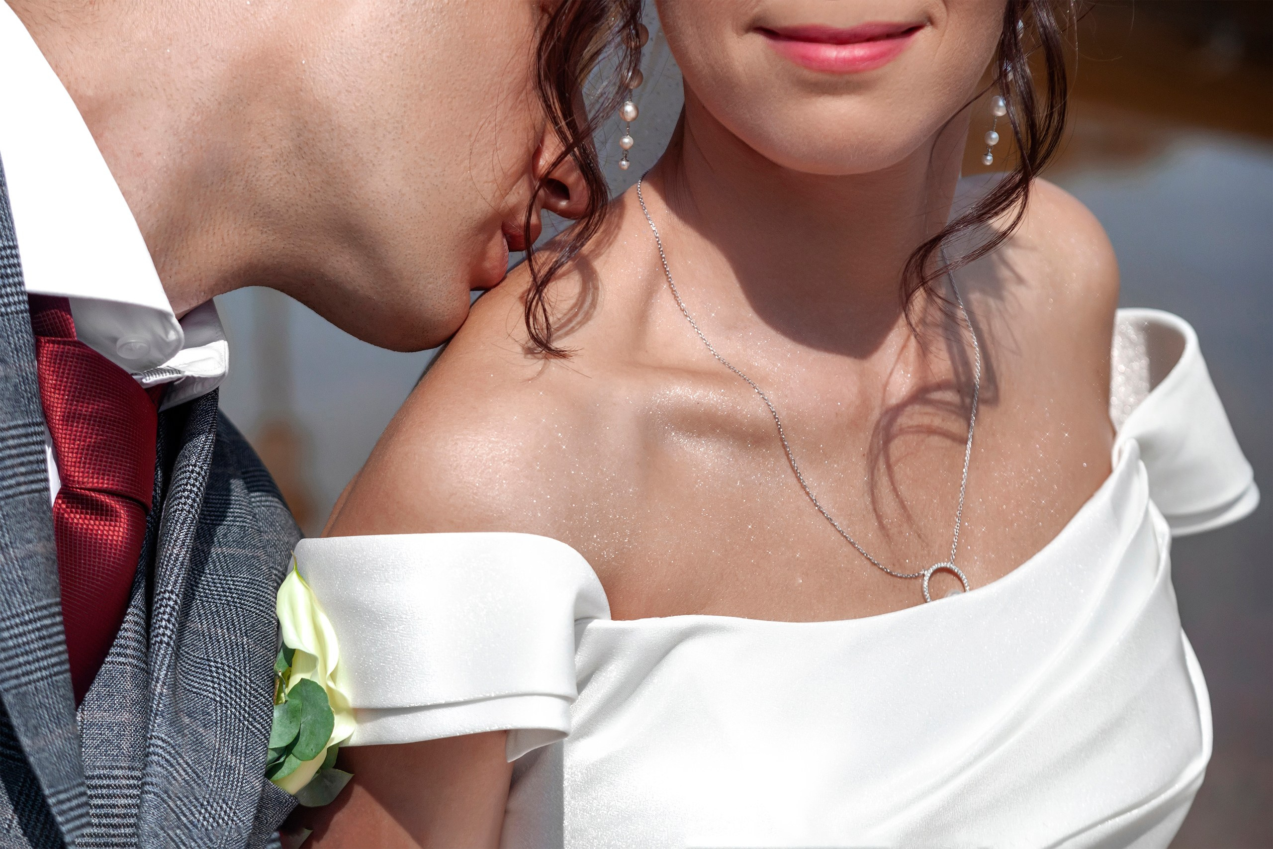 Жених целует невесту в плечо у фонтана