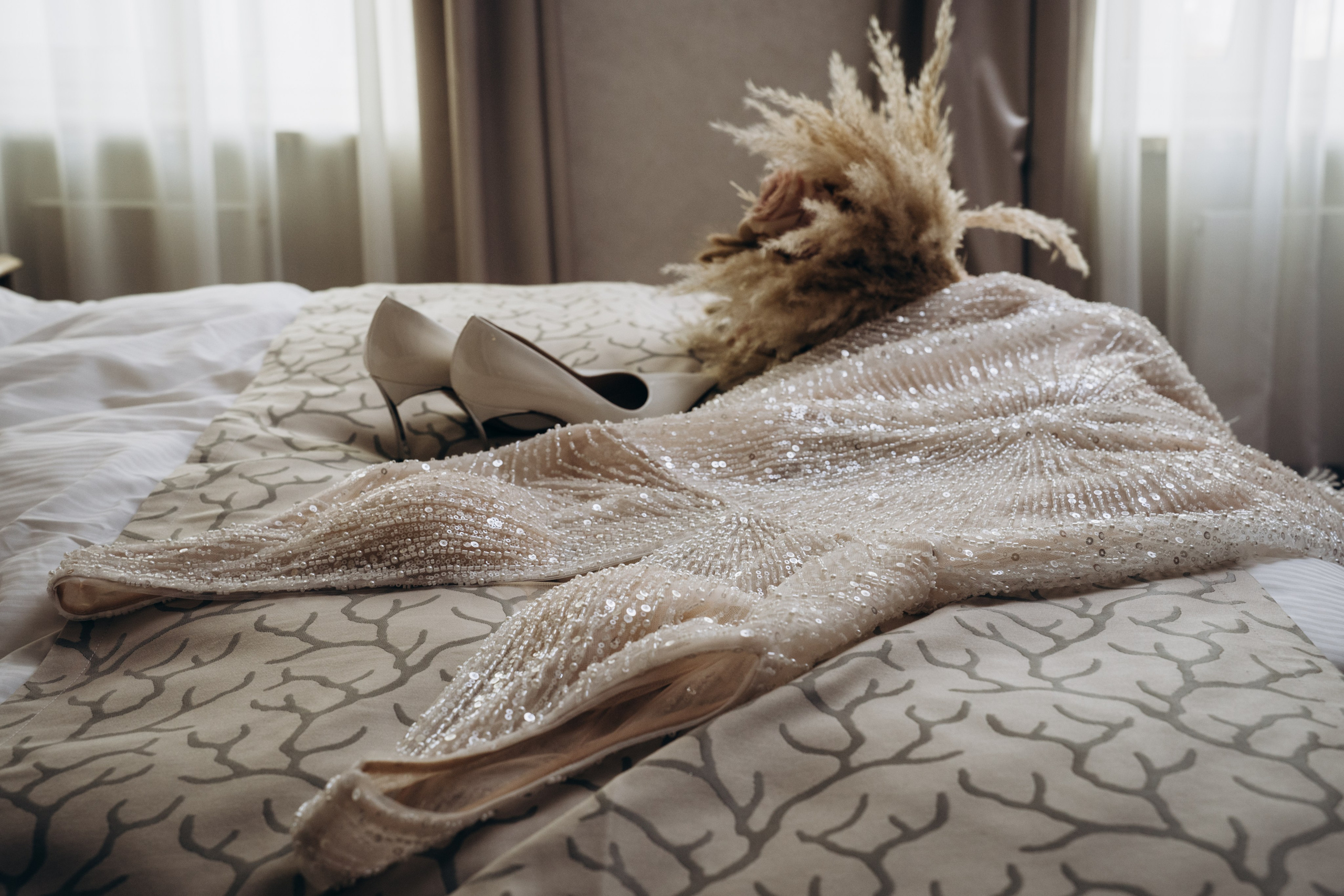 Невеста сидит в кресле, пока визажист наносит ей макияж — профессиональная свадебная фотосъемка в Москве с акцентом на подготовку.