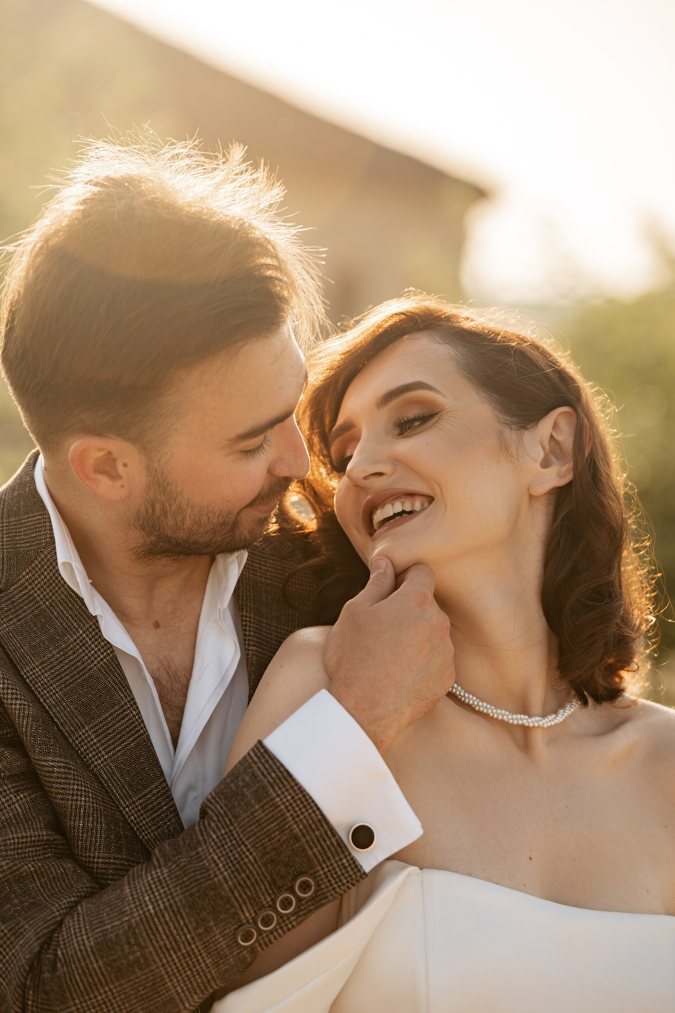 Свадебная фотосессия в Шато Андре — Детали: бокалы с вином на фоне молодоженов.