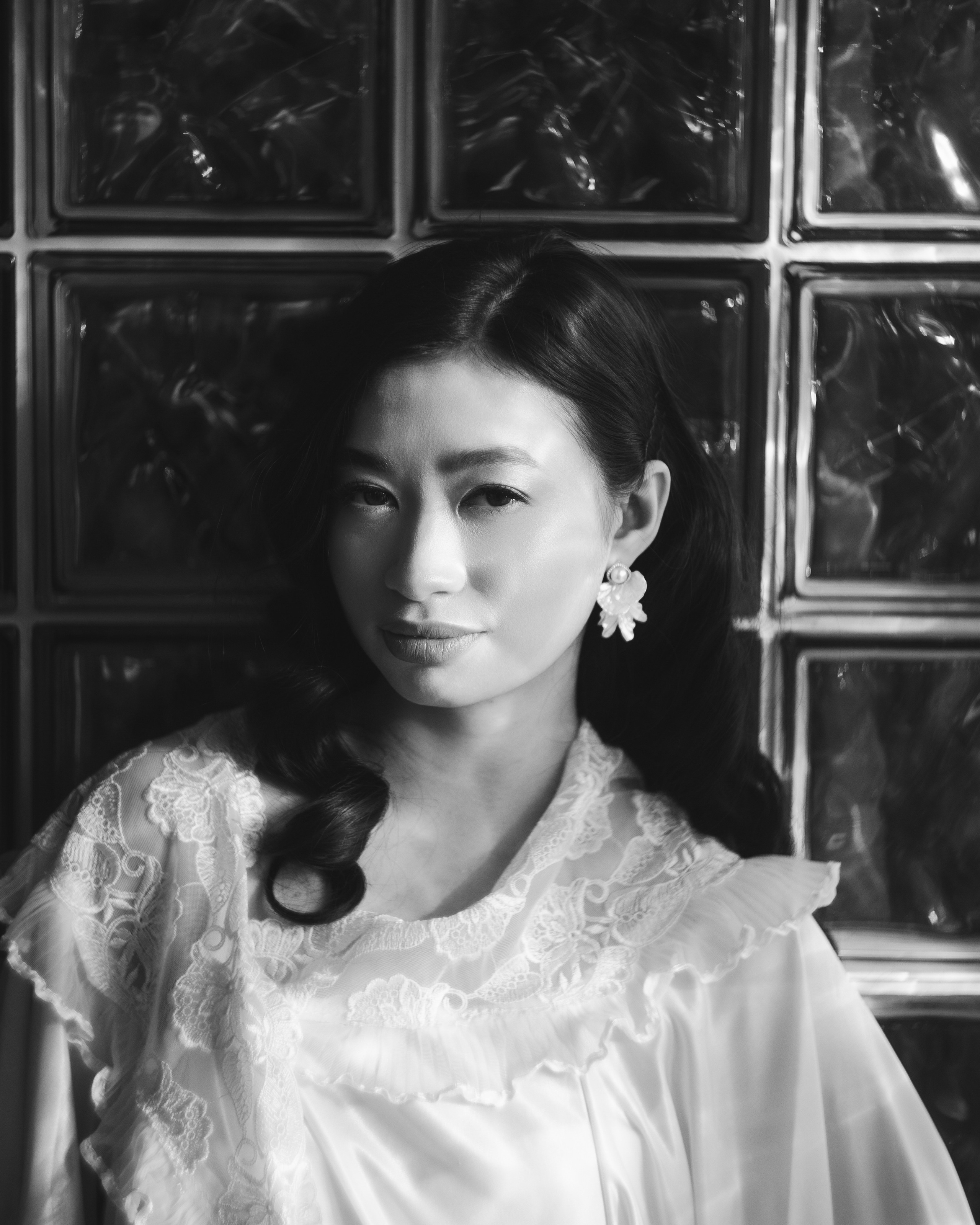 Черно-белый женский портрет невесты у стеклоблоков, свадебная фотосессия в ретро эстетике