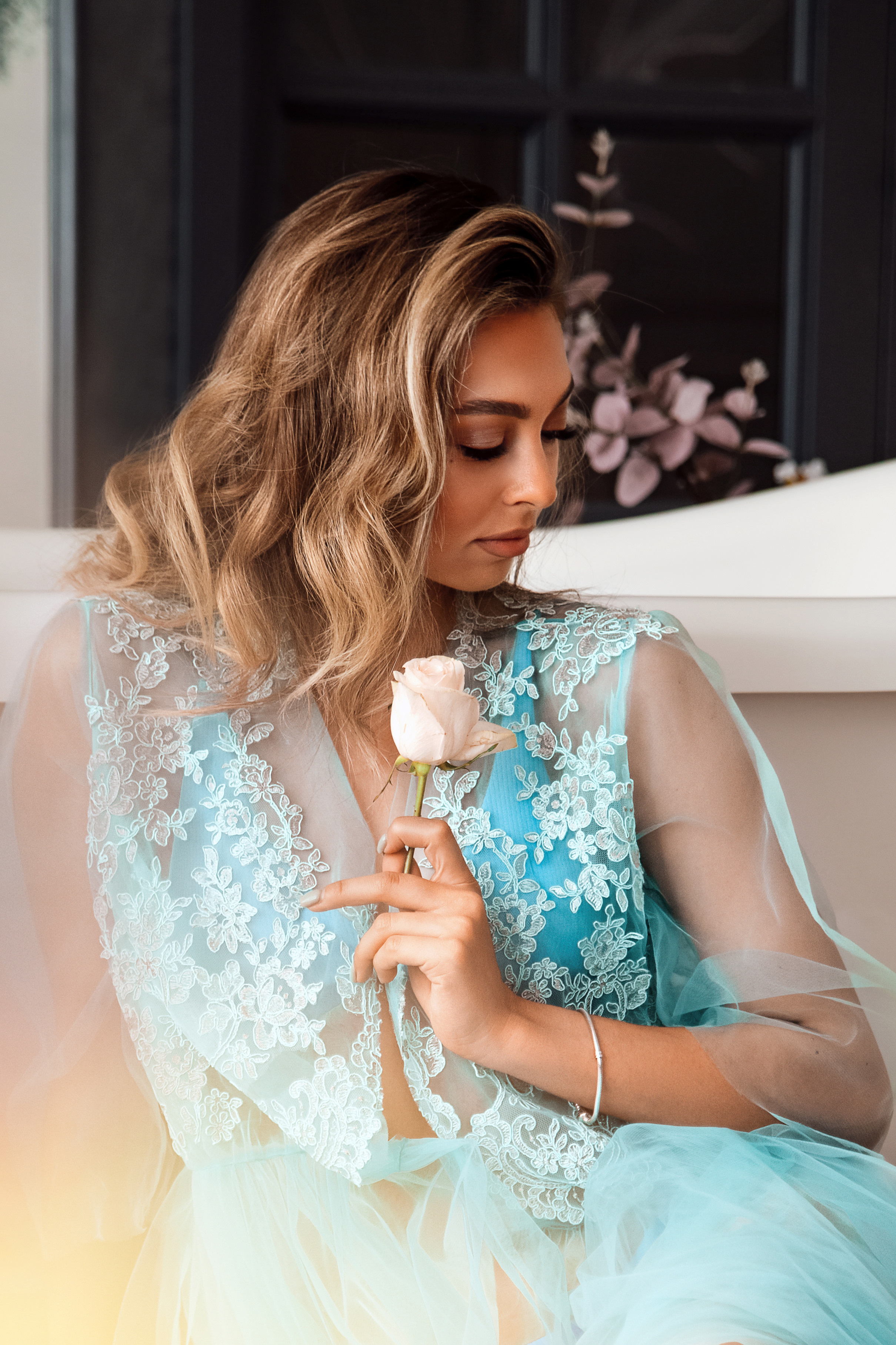 Будуарная фотосессия девушки в халате рядом с ванной. нежные цветочные декорации