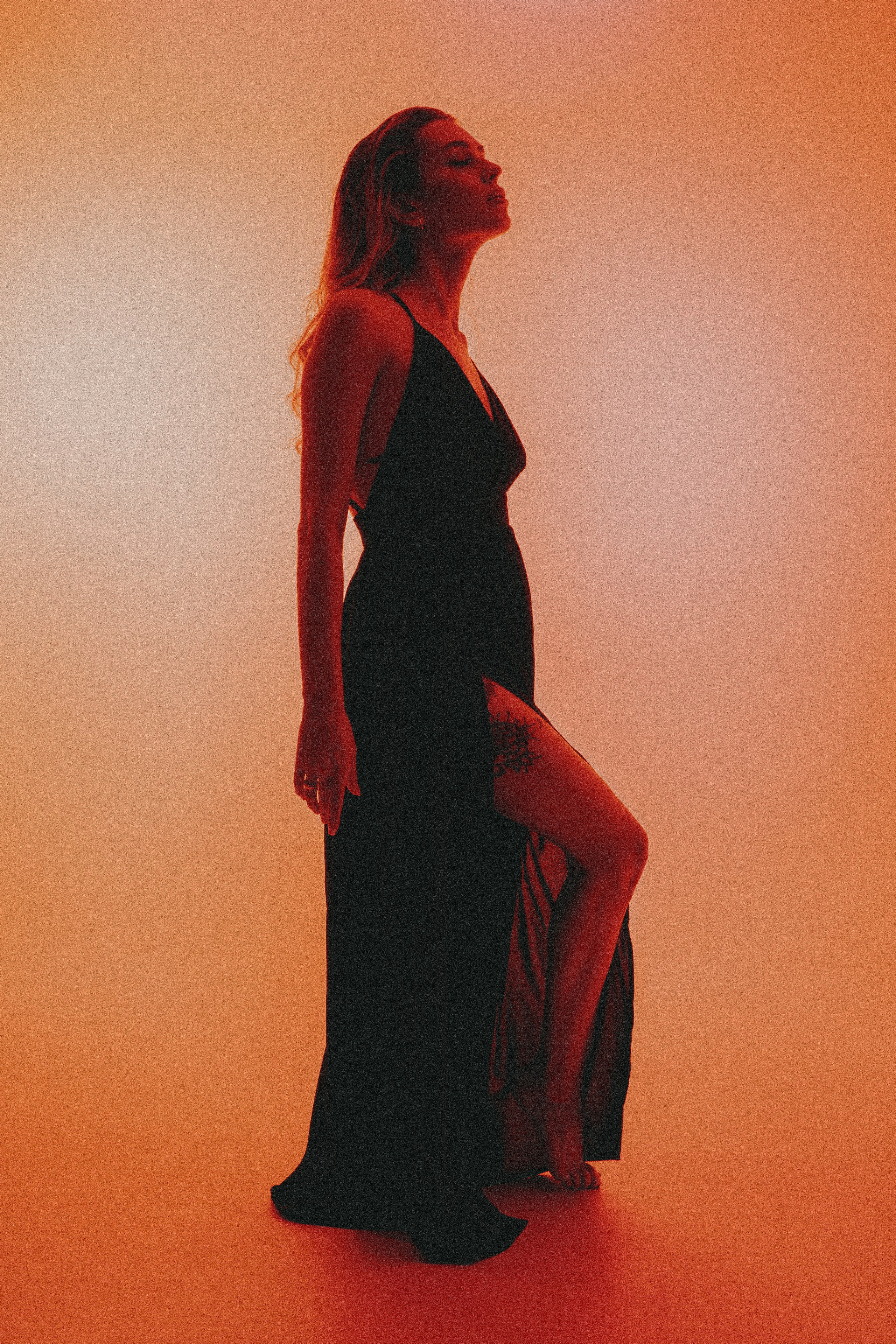 женская студийная фотосессия с красным ргб светом на циклораме