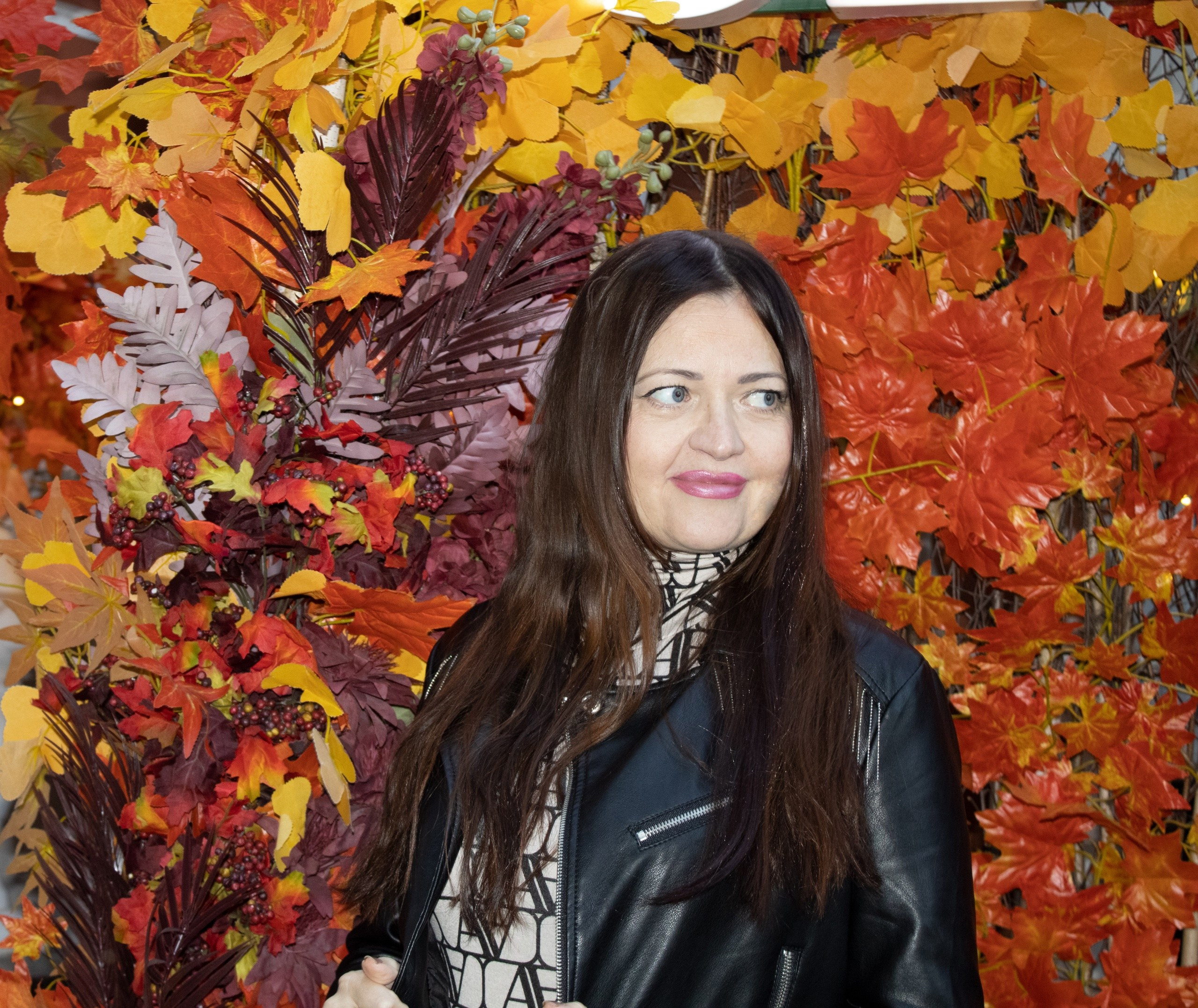 девушка стоит на фоне осенней листвы