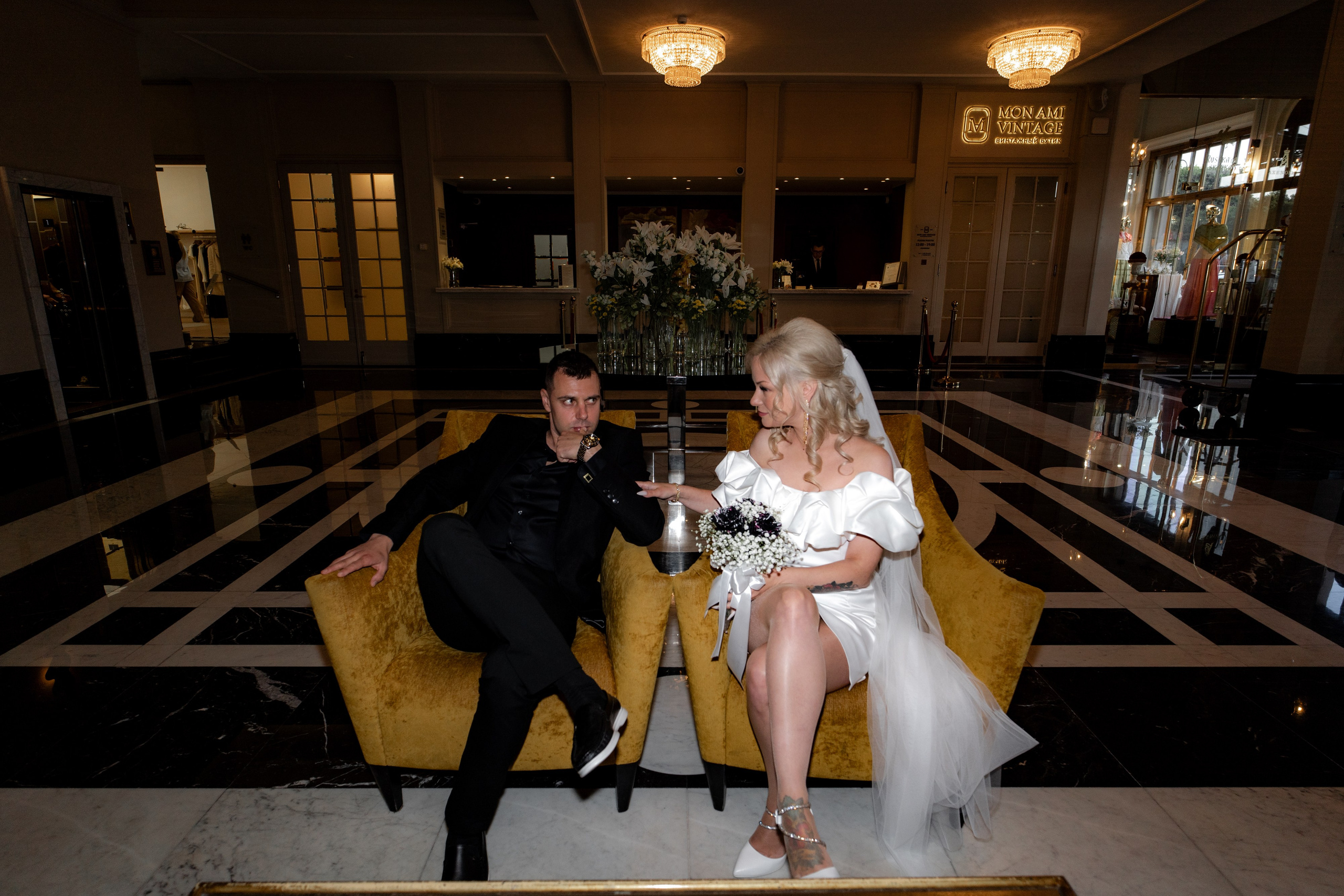 Жених и невеста сидят на креслах в холле гостиницы Англетер