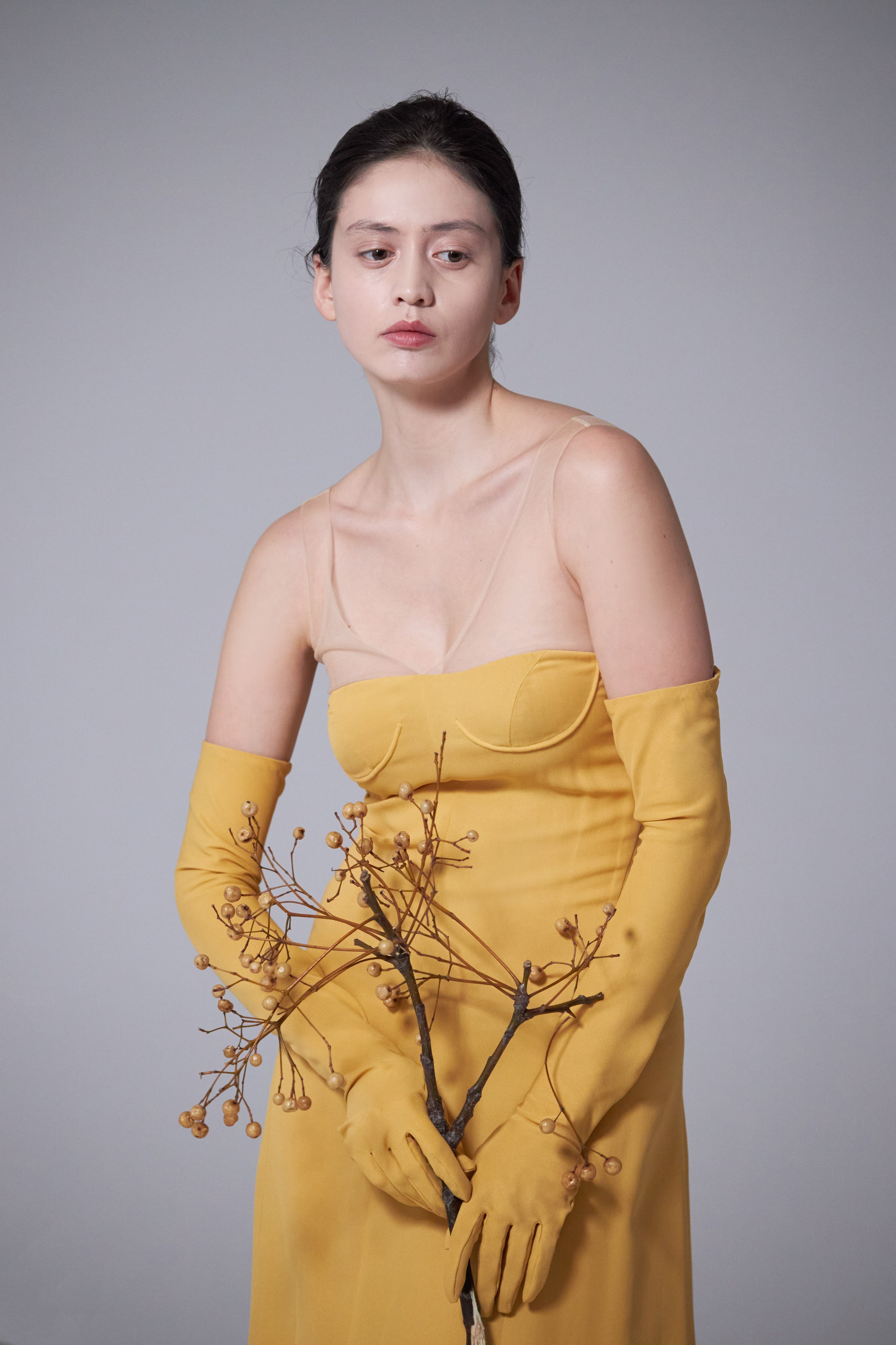 Портрет девушки в желтом платье с открытой грудью, в длинных перчатках и с сухоцветами в руках