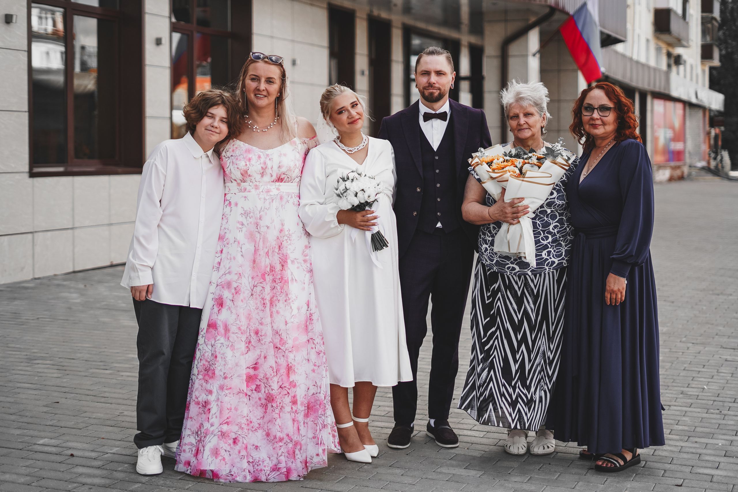 Невеста и жених с гостями возле загса