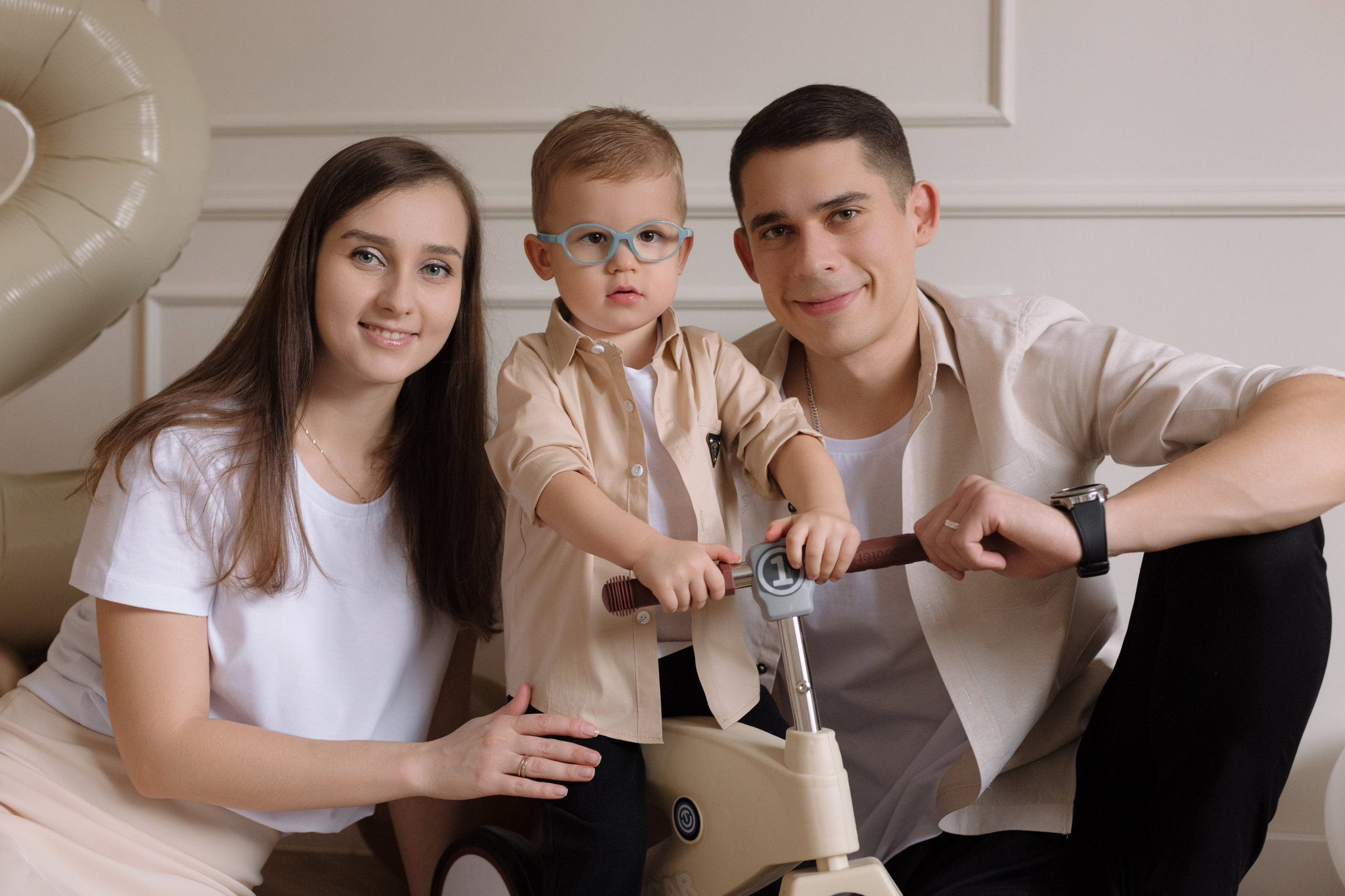 Семейная фотосессия в Таганроге в студии — родители и маленький сын на беговеле, фотограф Бакарюк Антон