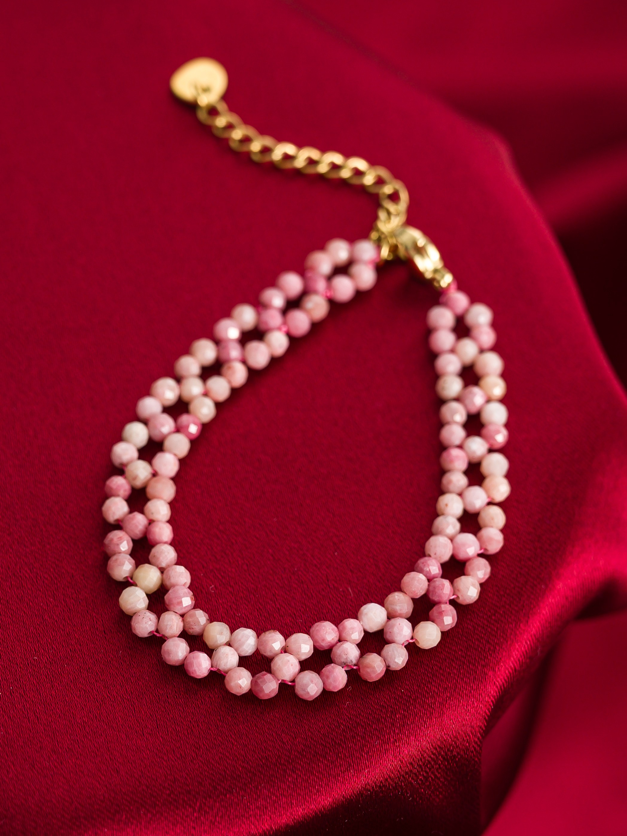 Фото товара: браслет из бусин в два ряда на красном фоне — предметная съемка для онлайн-продаж