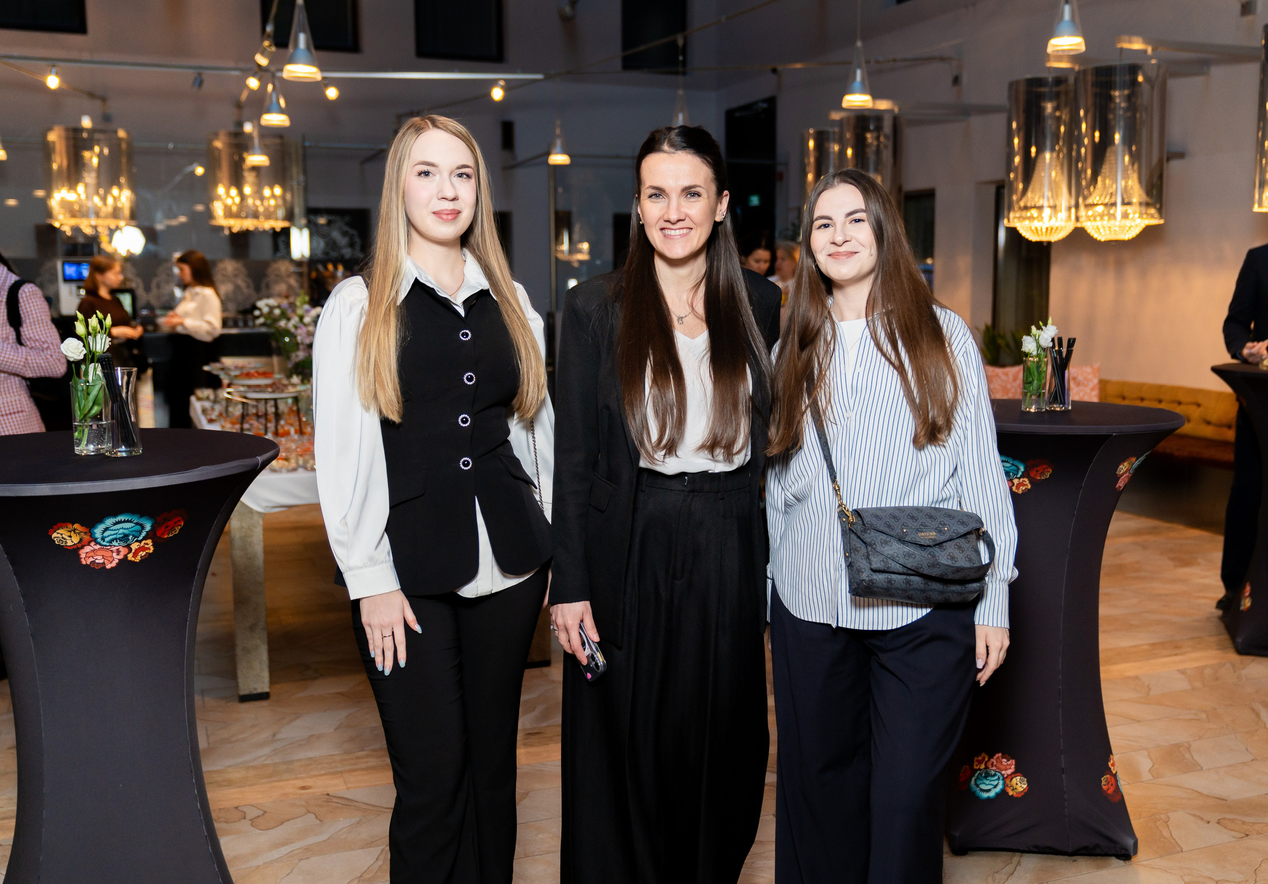 "Три девушки позируют на высоких столах в банкетном зале. Фото Евгения Мальцева, Radisson Sonya Hotel St. Petersburg.