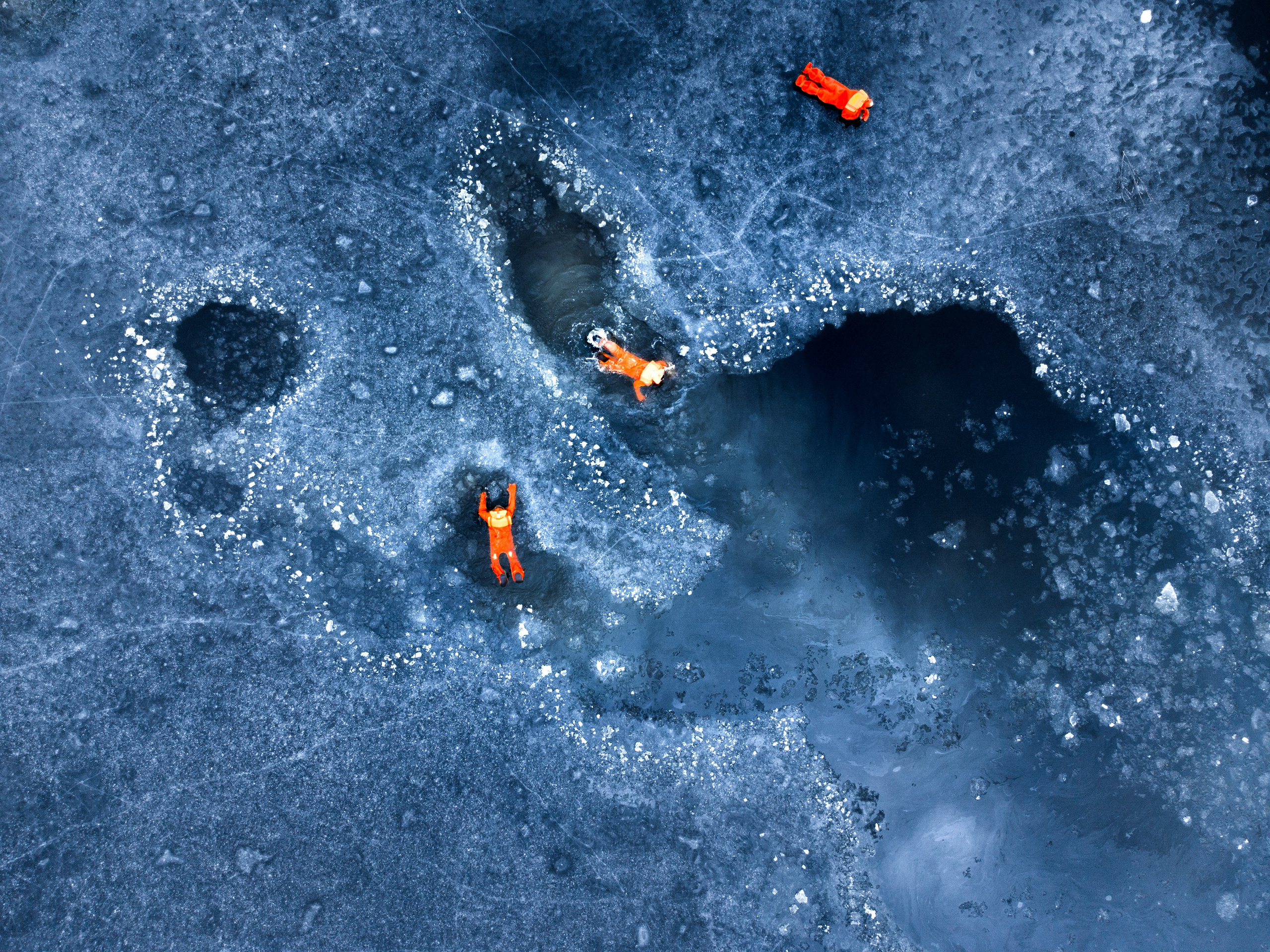 Люди купаются среди льдин, в спасательных оранжевых термо костюмах, айс флоатинг Ярославль