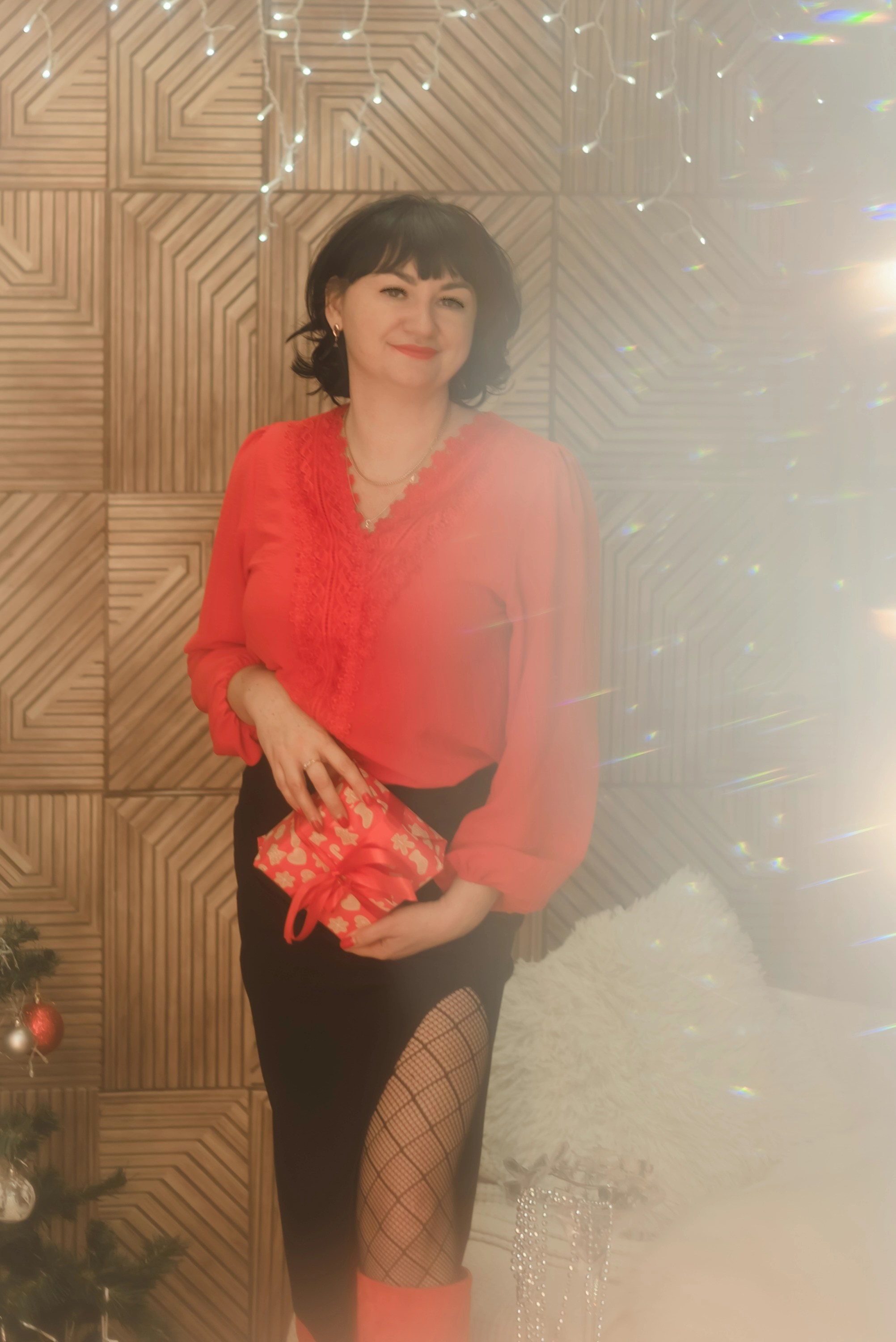 На фото женщина с подарком на новый год в студии.