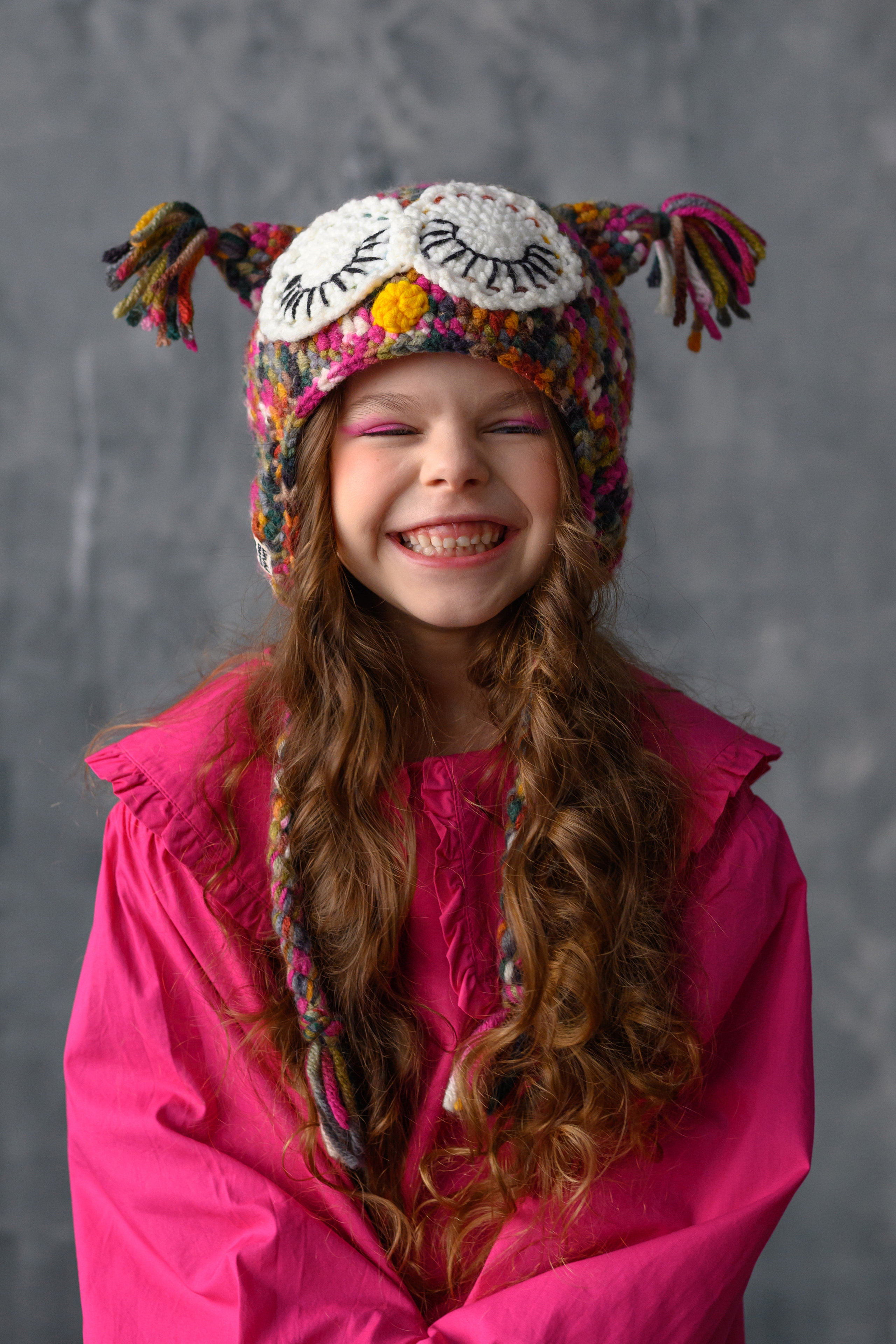 Веселая девочка смеётся в забавной шапке с глазами филина, г. Нижневартовск