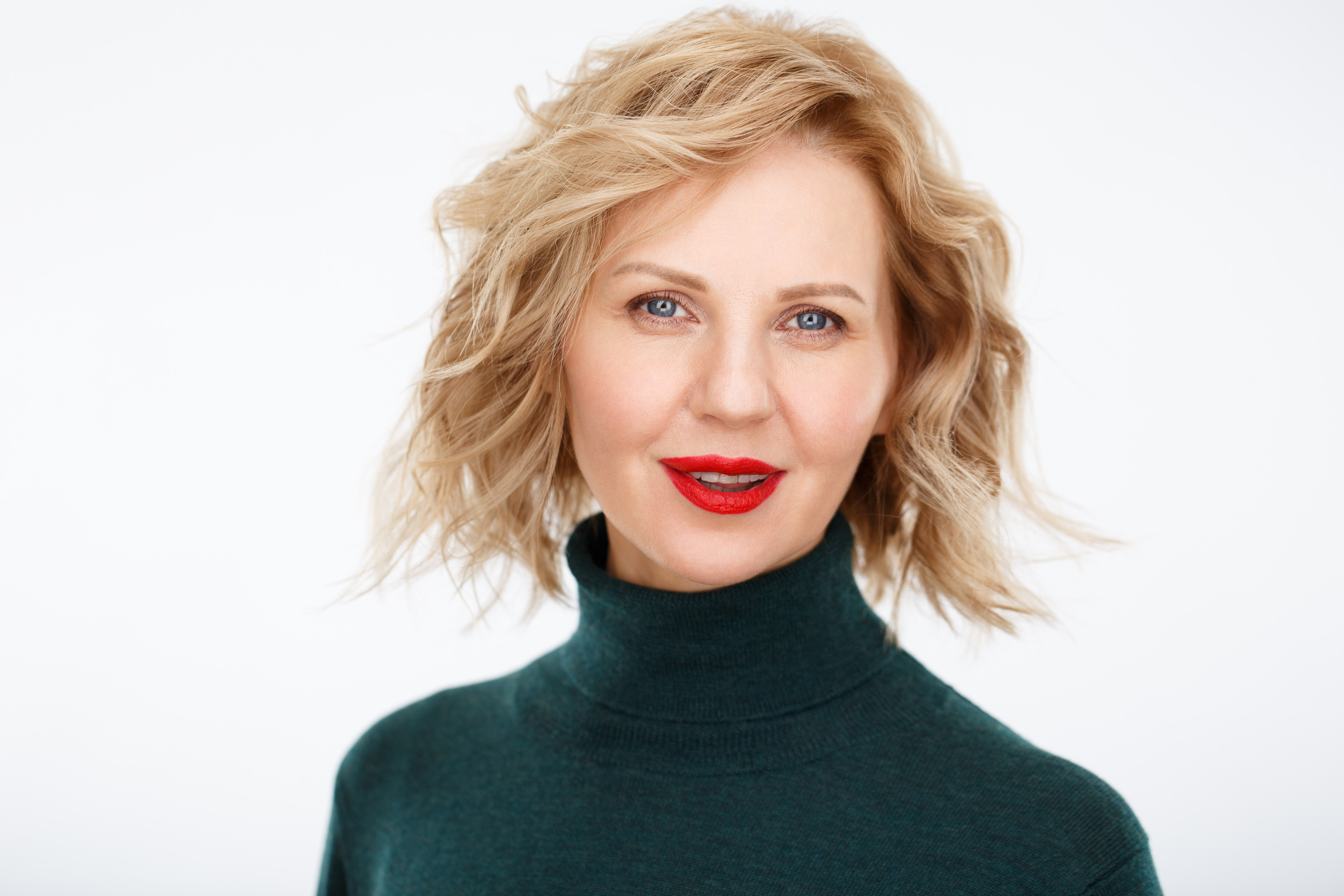 Неформальный хедшот-портрет молодой улыбающейся женщины на белом фоне.