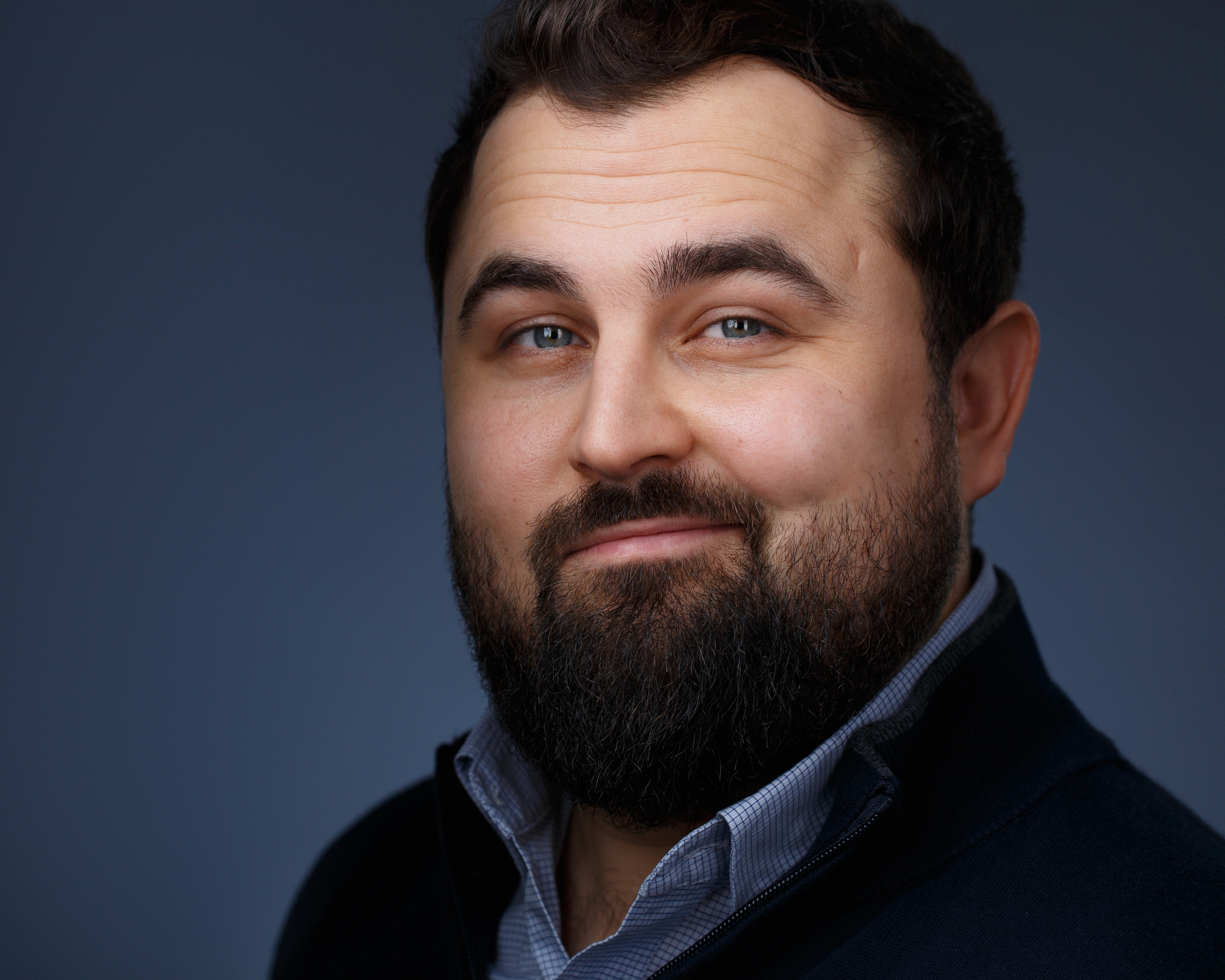 Хедшот. Студийный портрет для продвижения личного бренда мужчины с бородой на тёмном фоне.