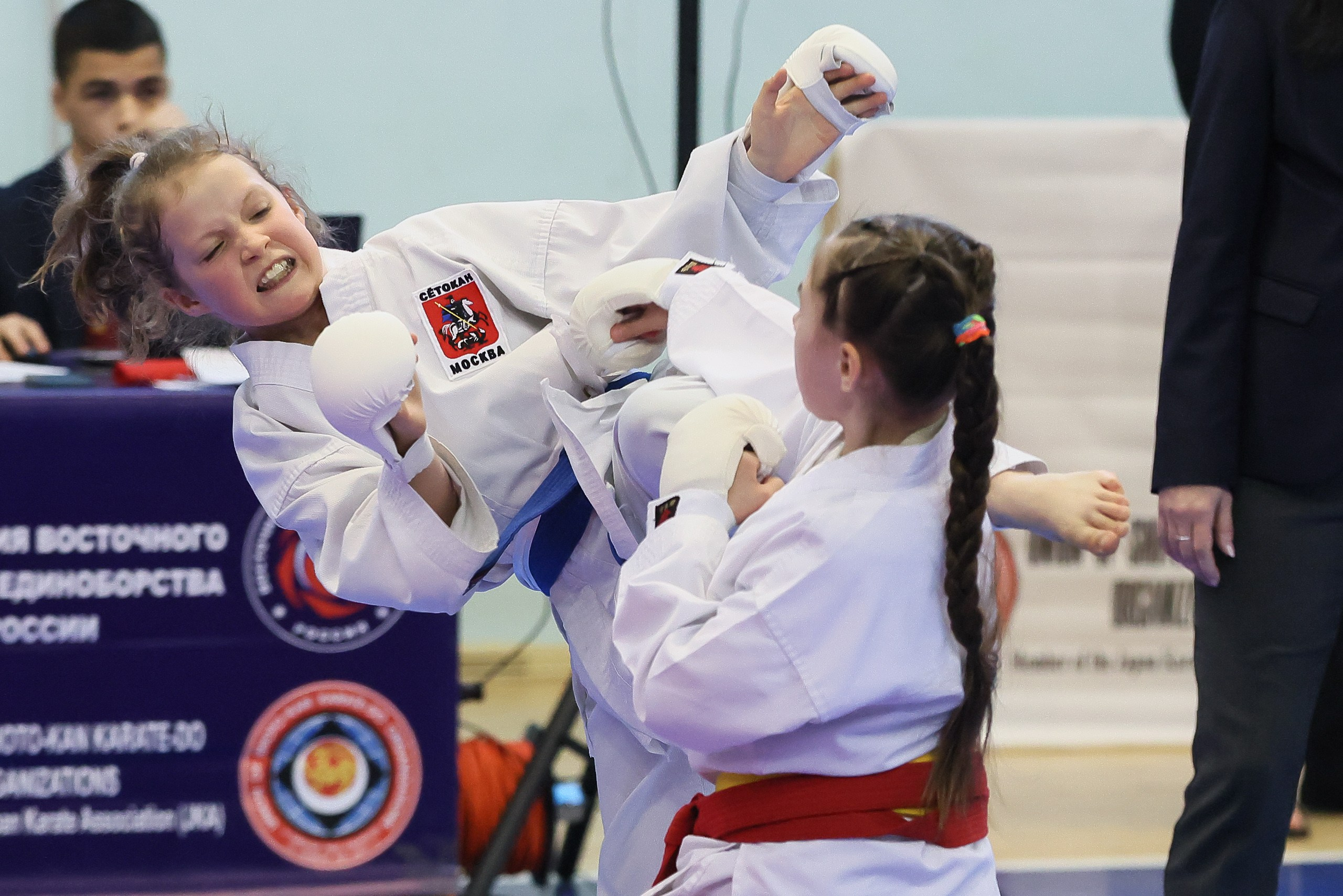 Девочка карате наносит удар ногой в кумите