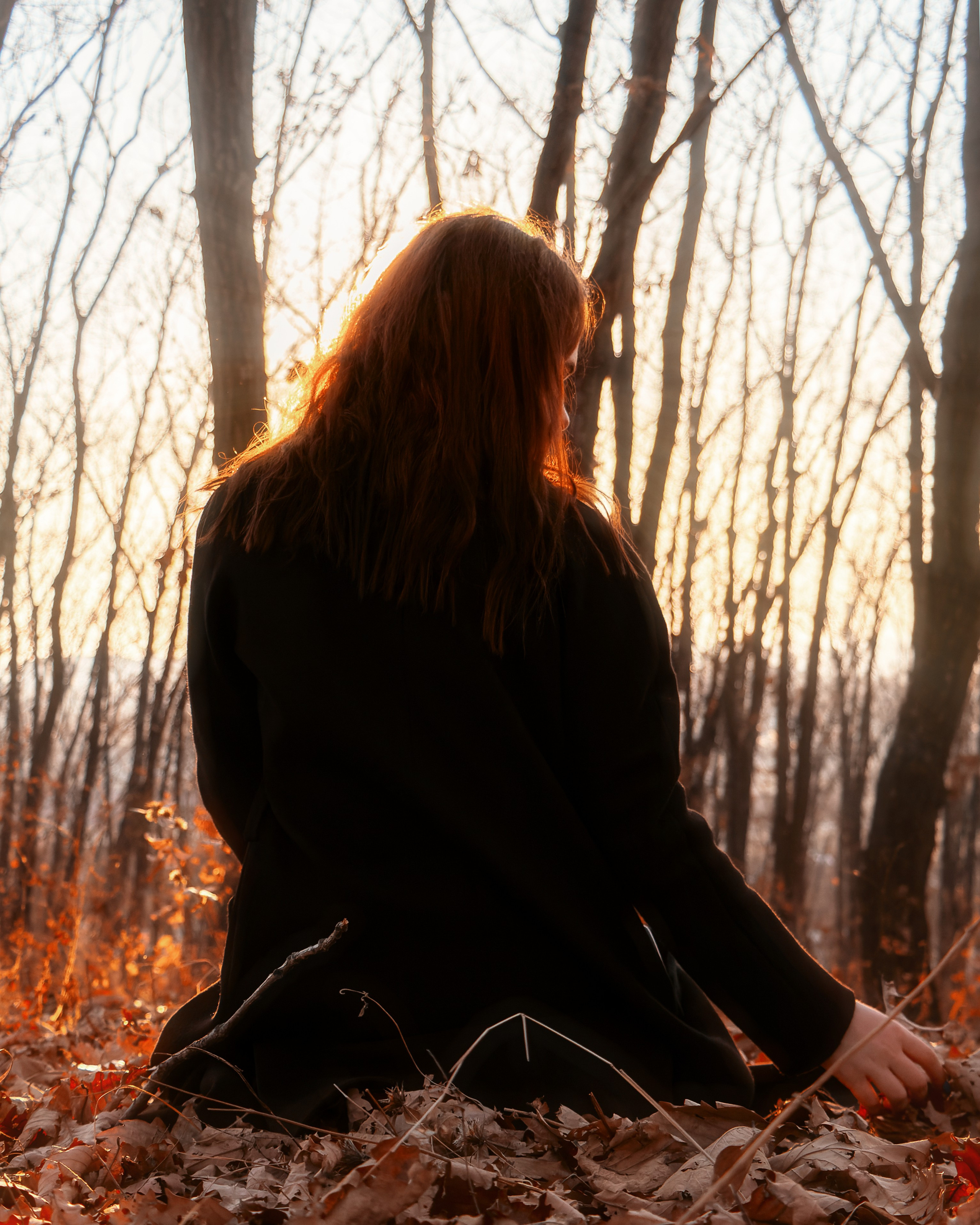 Девушка осенью на природе среди листьев на закате