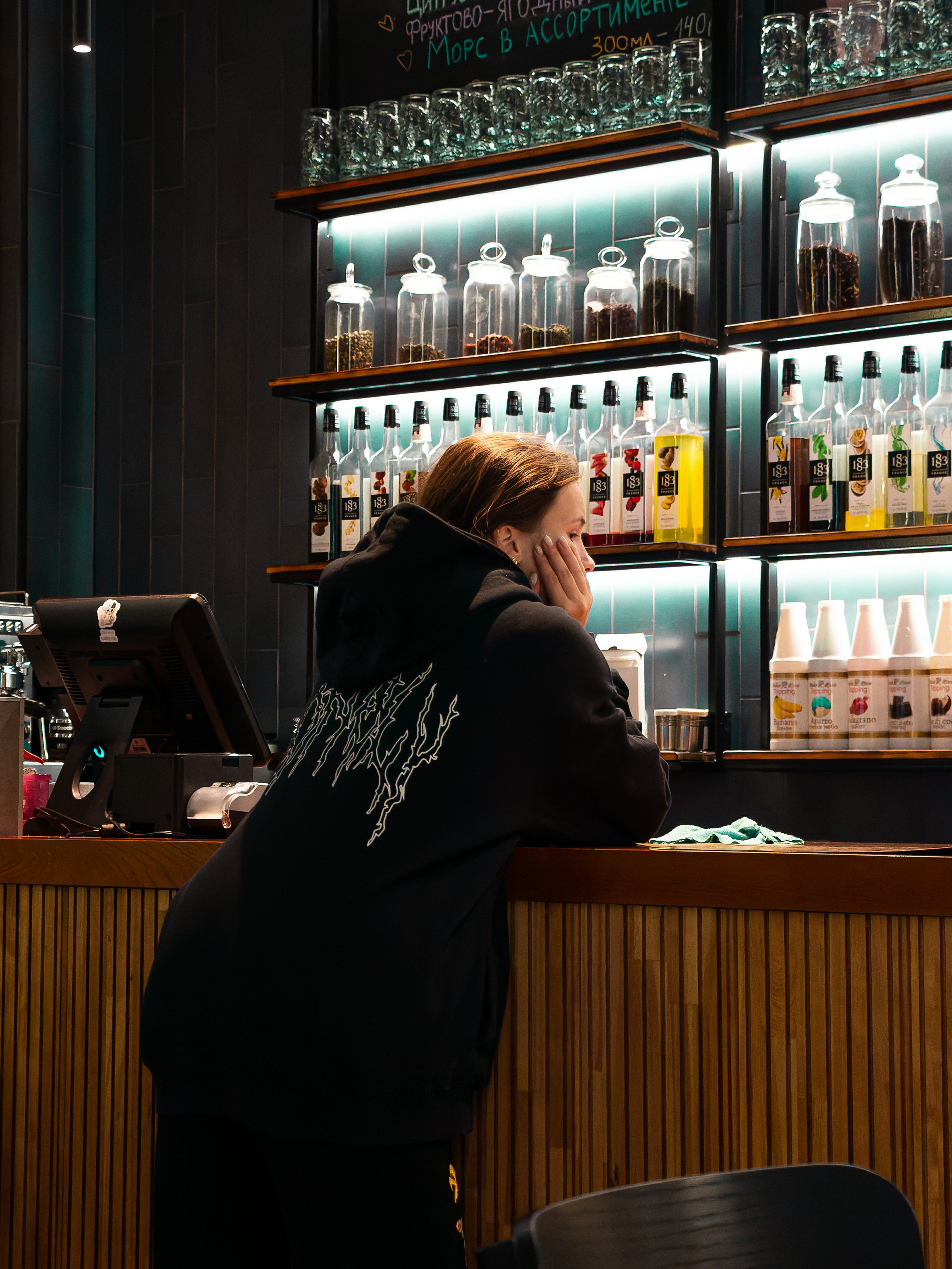 Фото девушки вечером в кафе около стойки