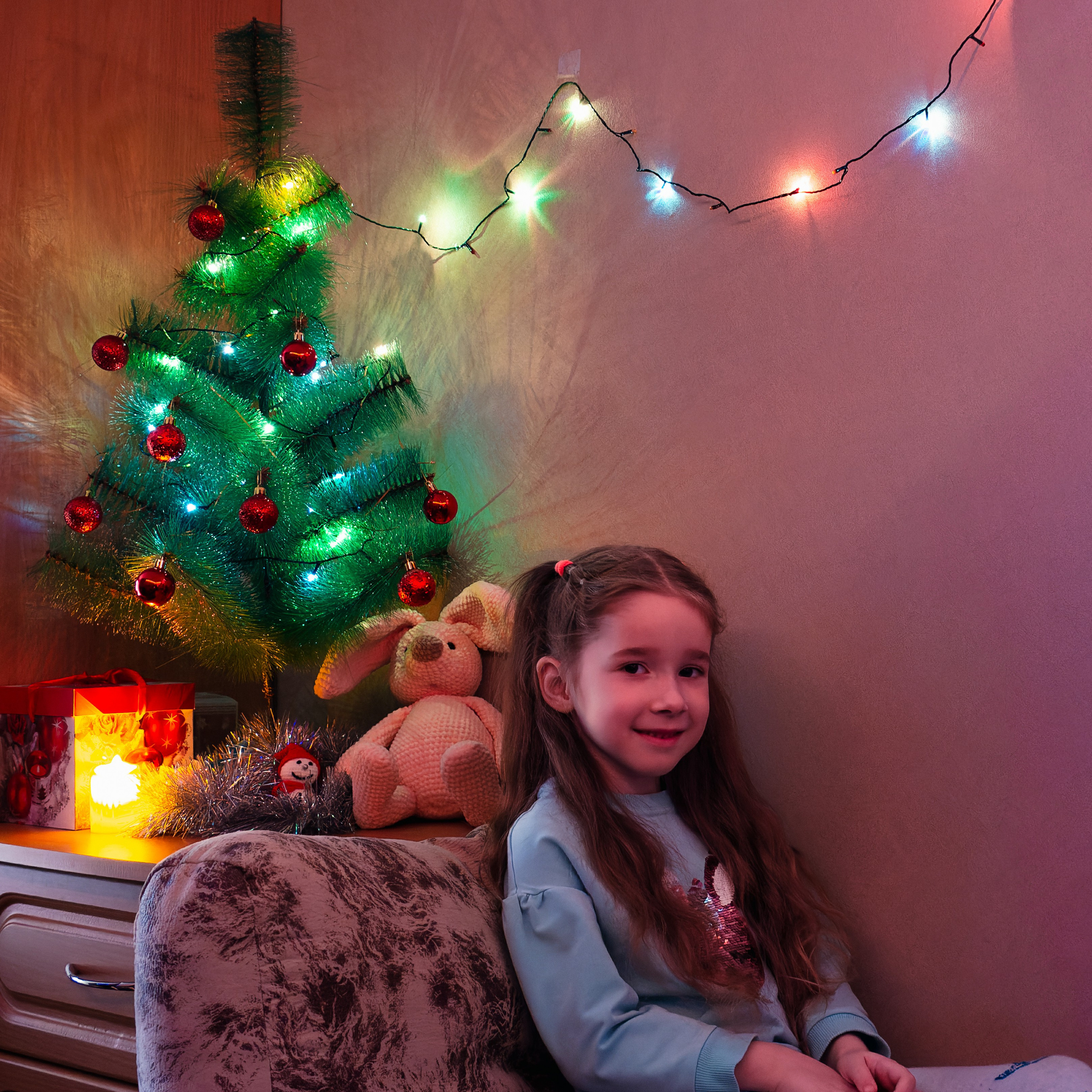 Девочка в новогодней обстановке около ёлки