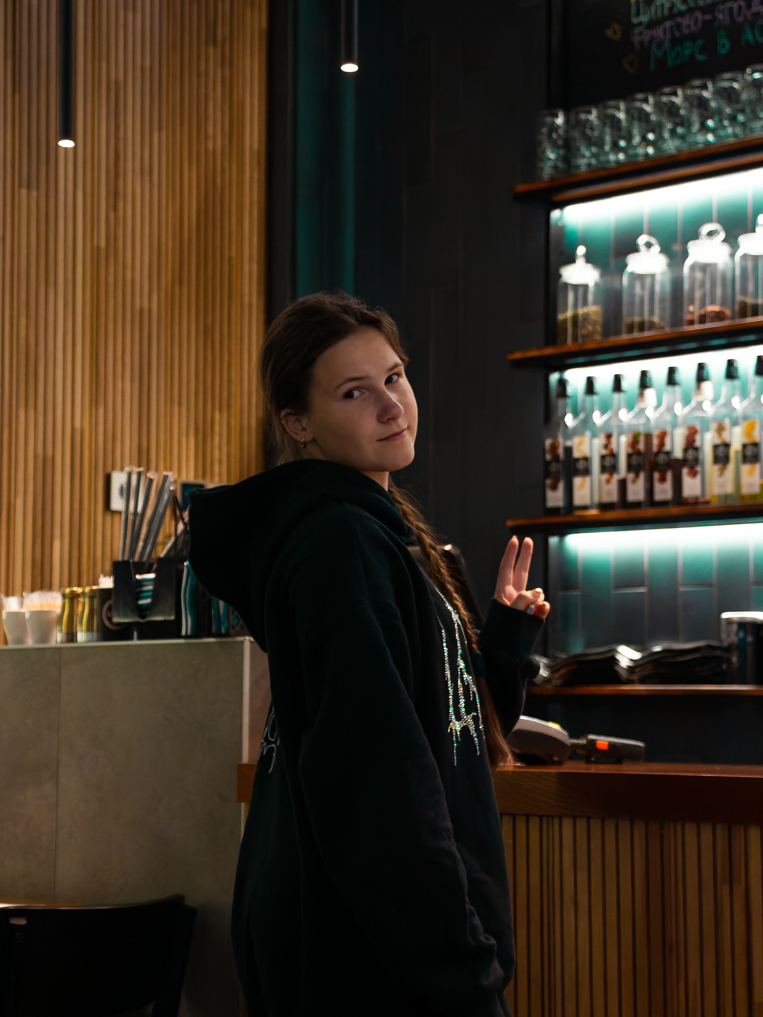 Фото девушки вечером в кафе около стойки