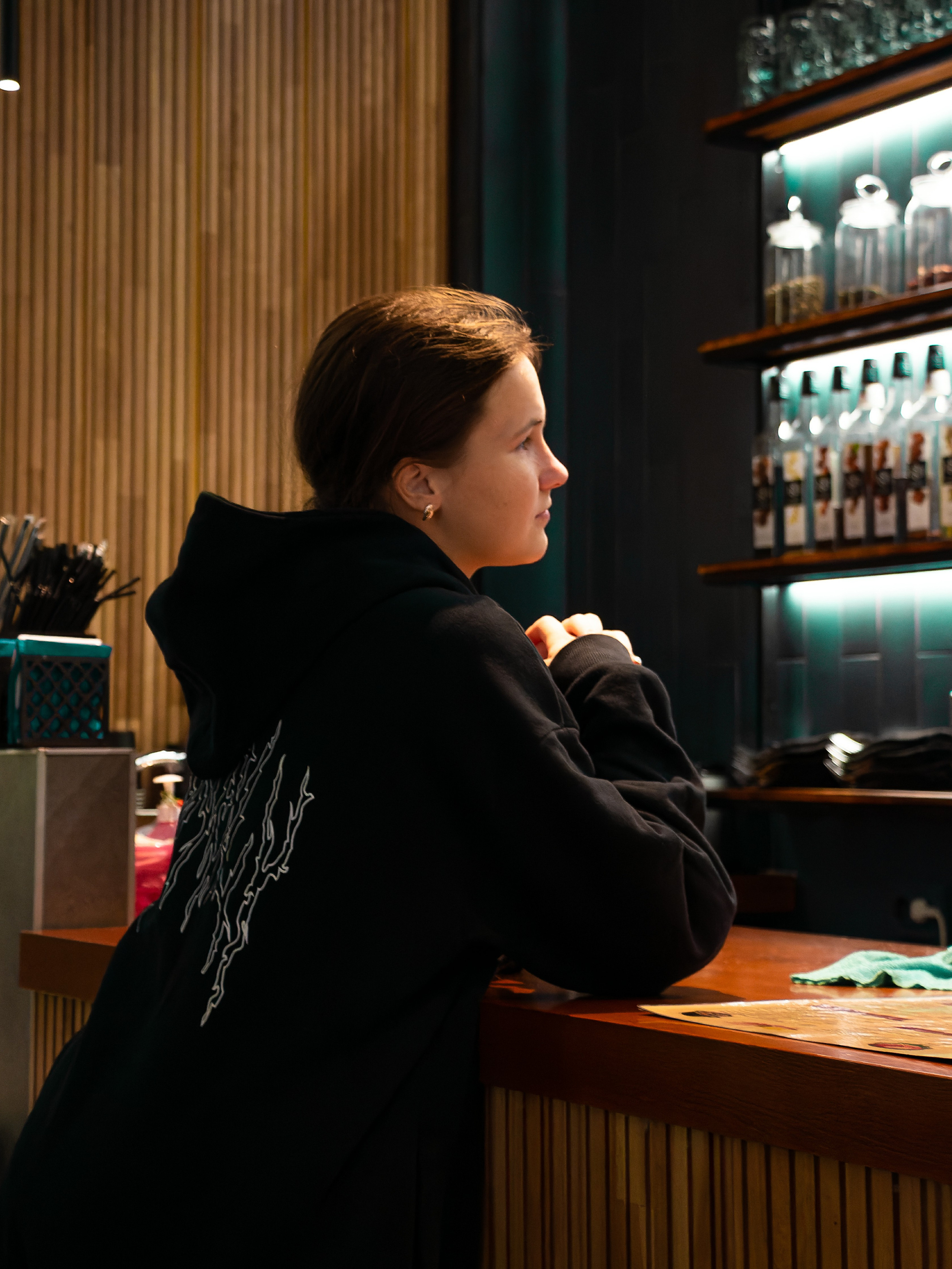 Фото девушки вечером в кафе около стойки