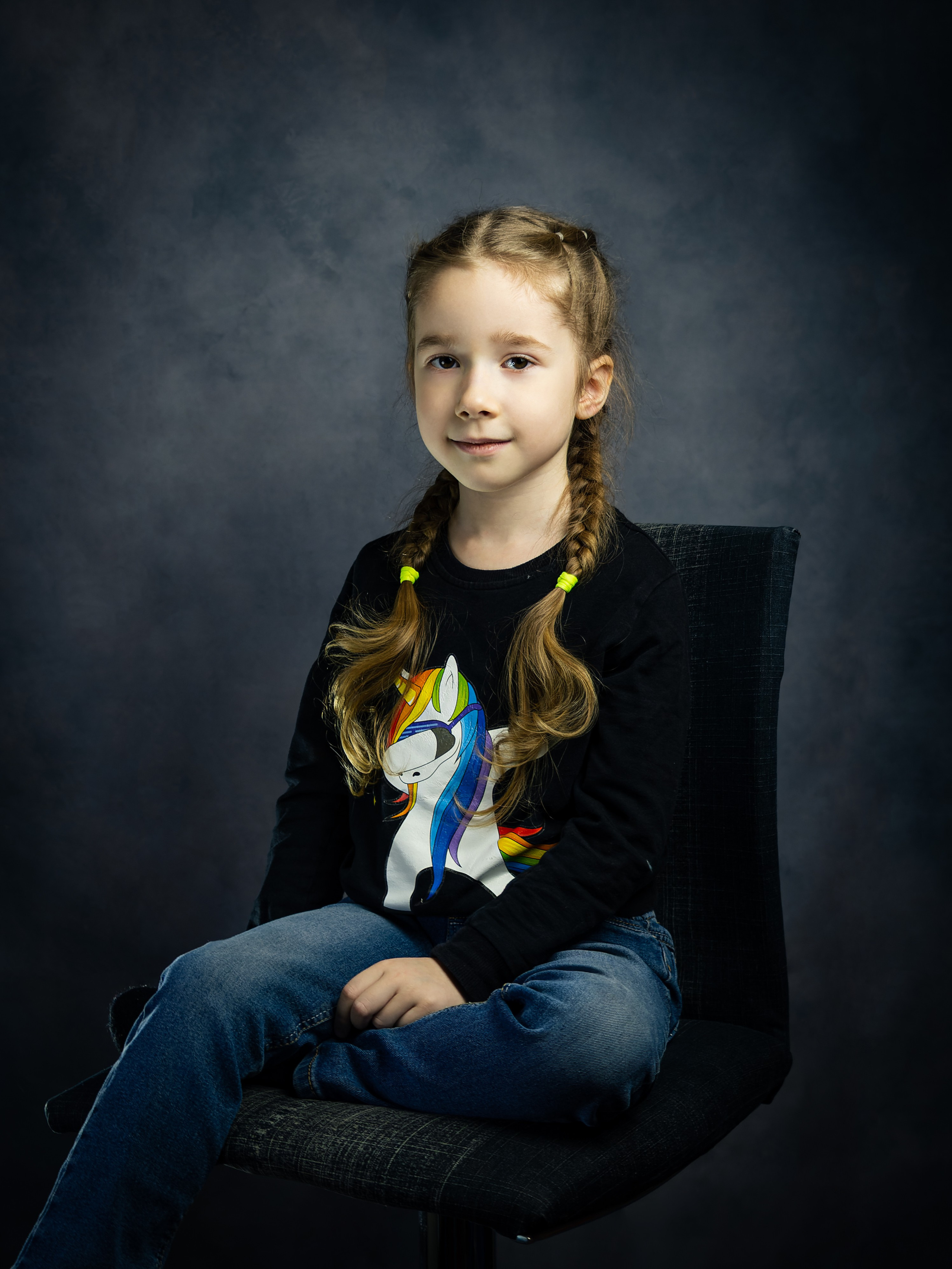 Студийный портрет девочки на сером фоне