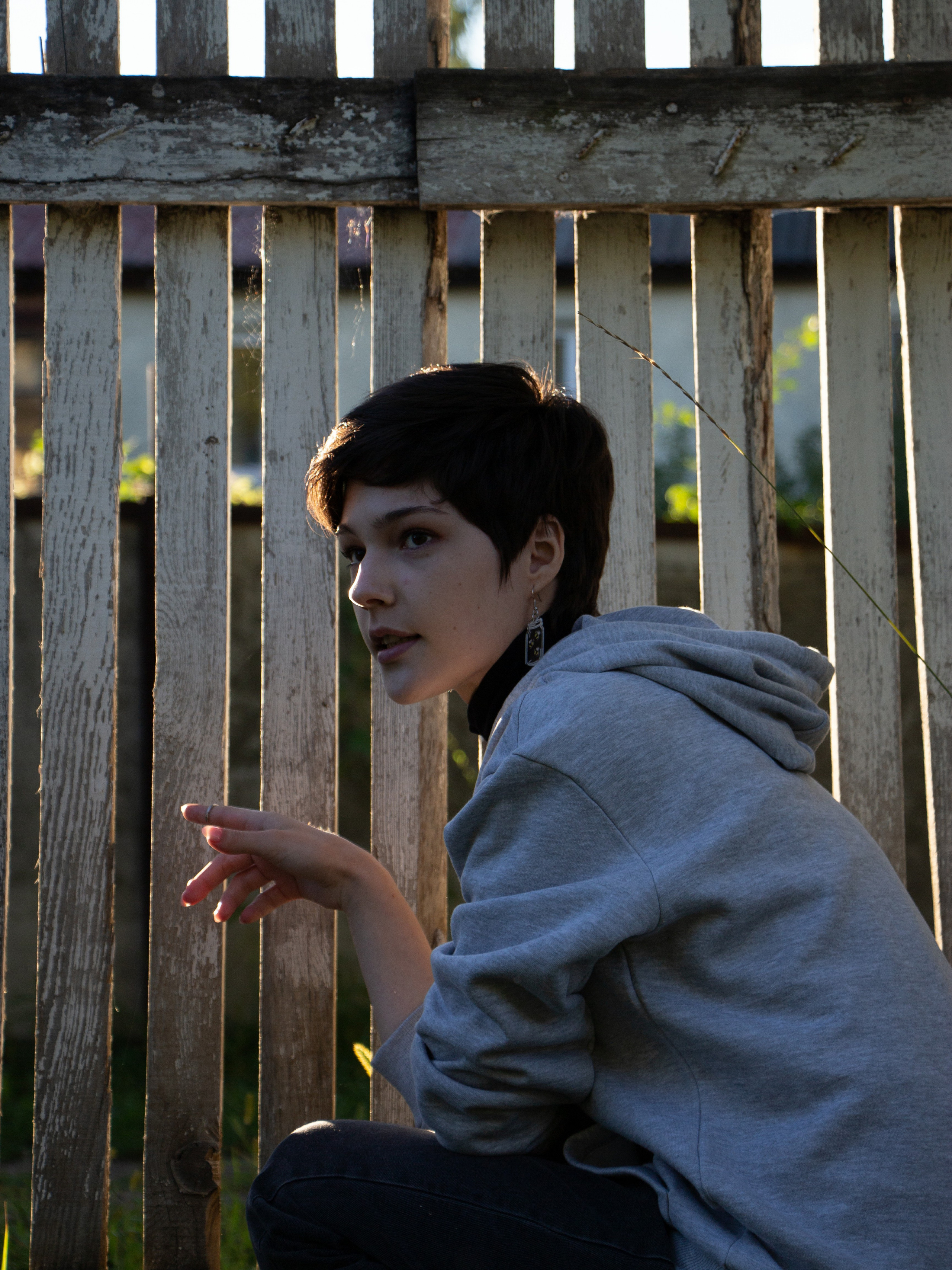 Девушка на улице в ярком солнечном свете за забором