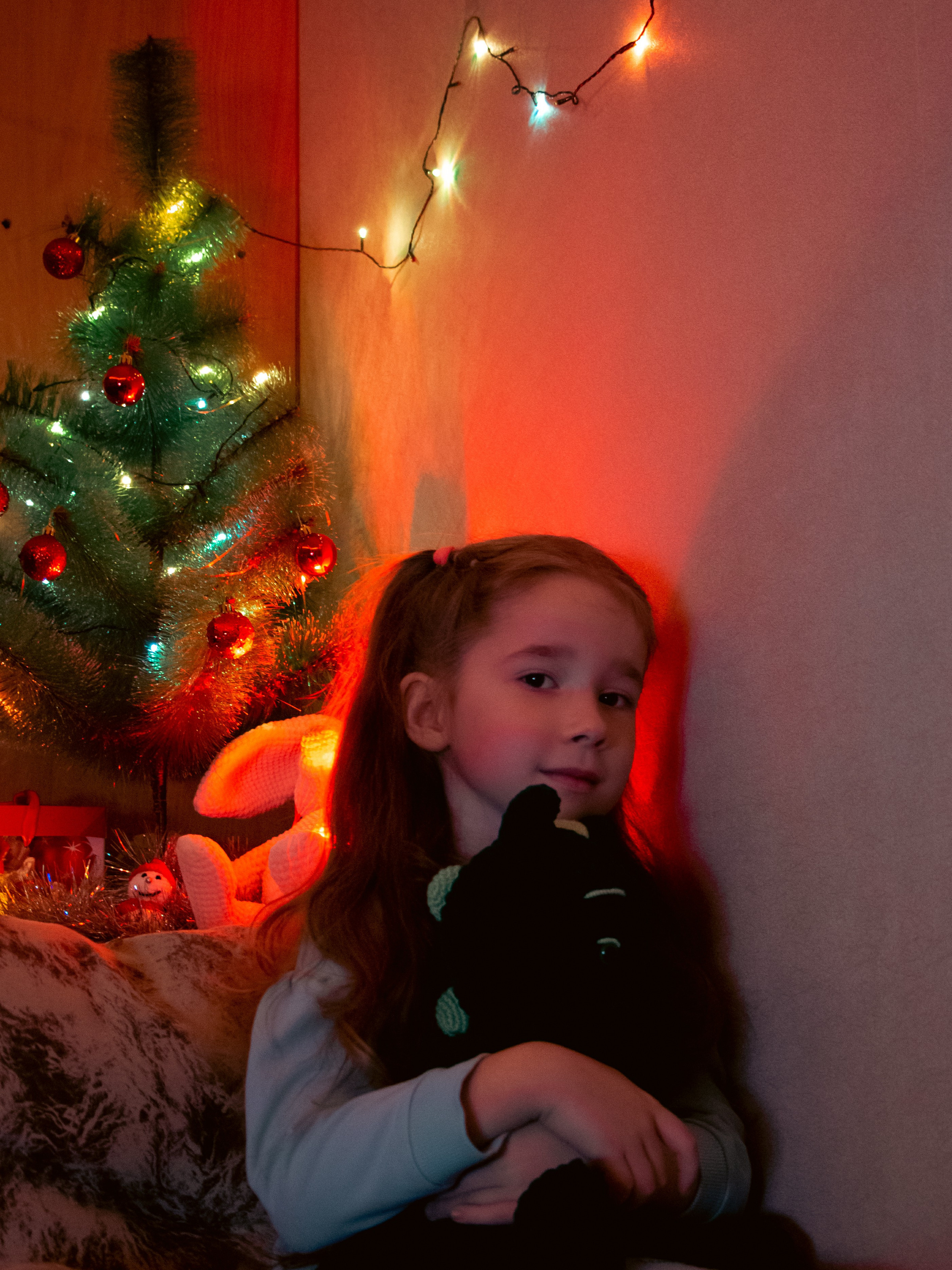 Девочка в новогодней обстановке около ёлки