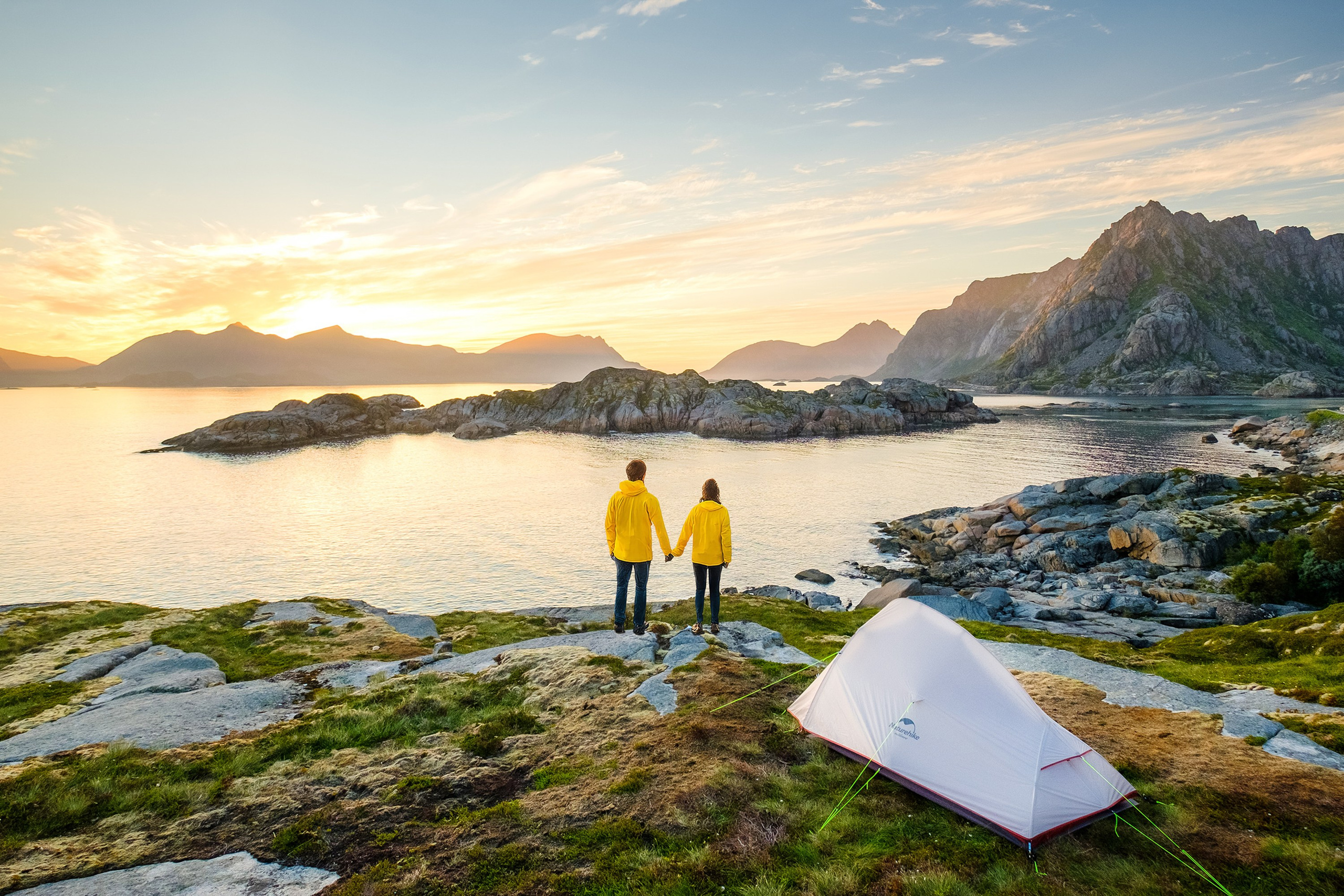 Пара у палатки на берегу на закате, поход в горах