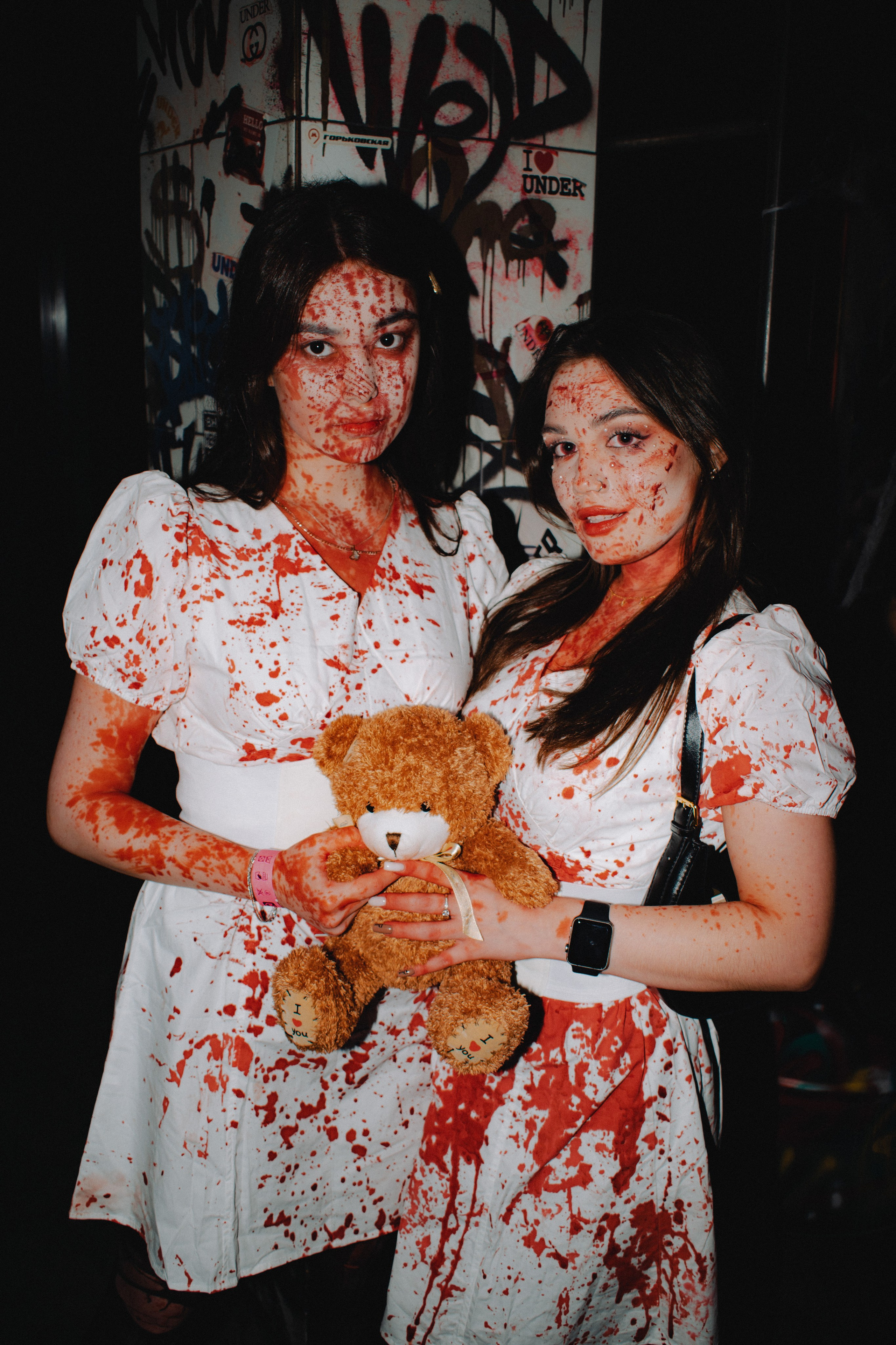 Клубная съёмка в хэллоуин две девушки в белом платье измазанные красной краской с плюшевым пишкой на фон заброшенного здания хоррор
