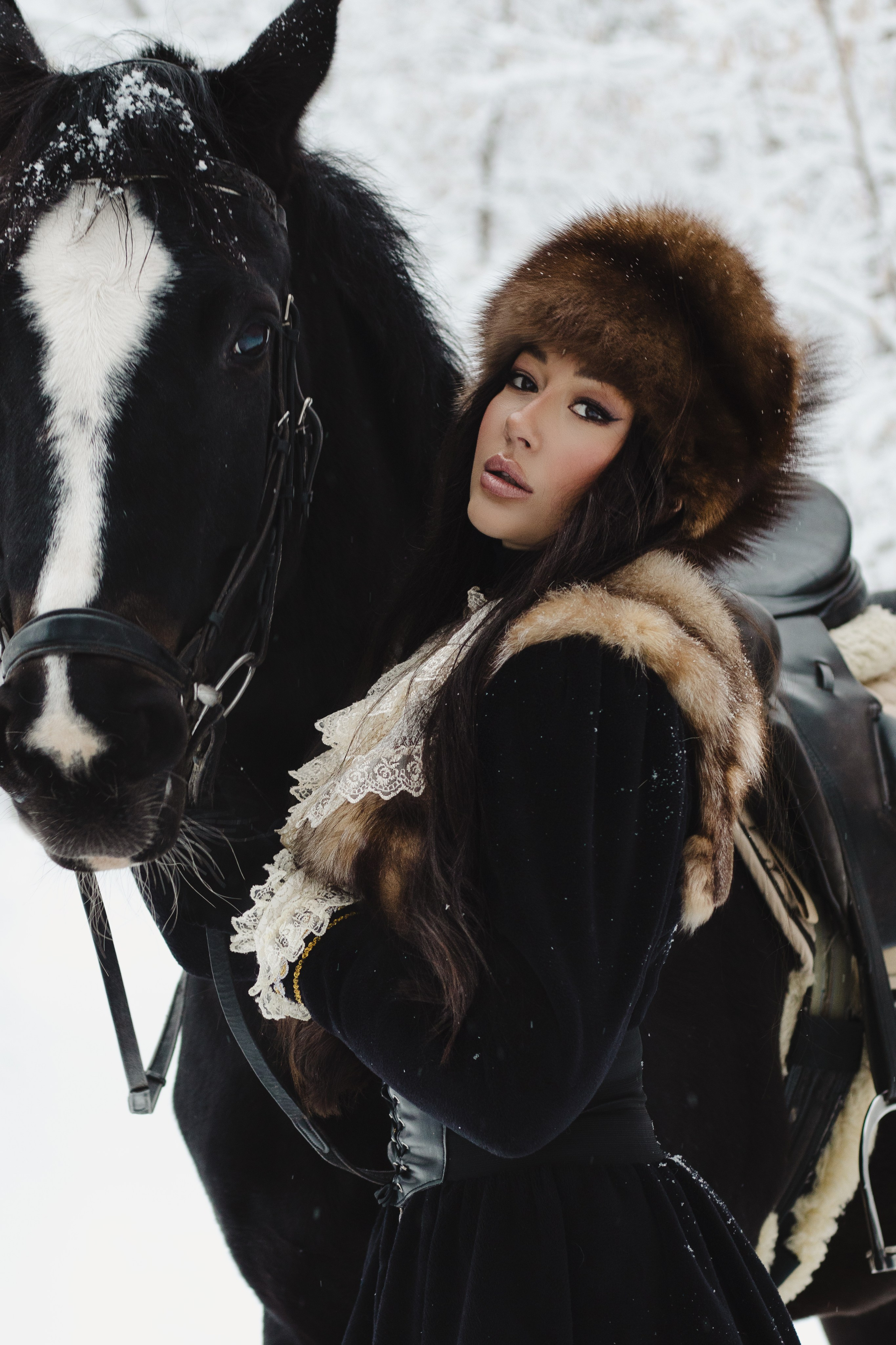 Красивая девушка с лошадью в зимнем лесу