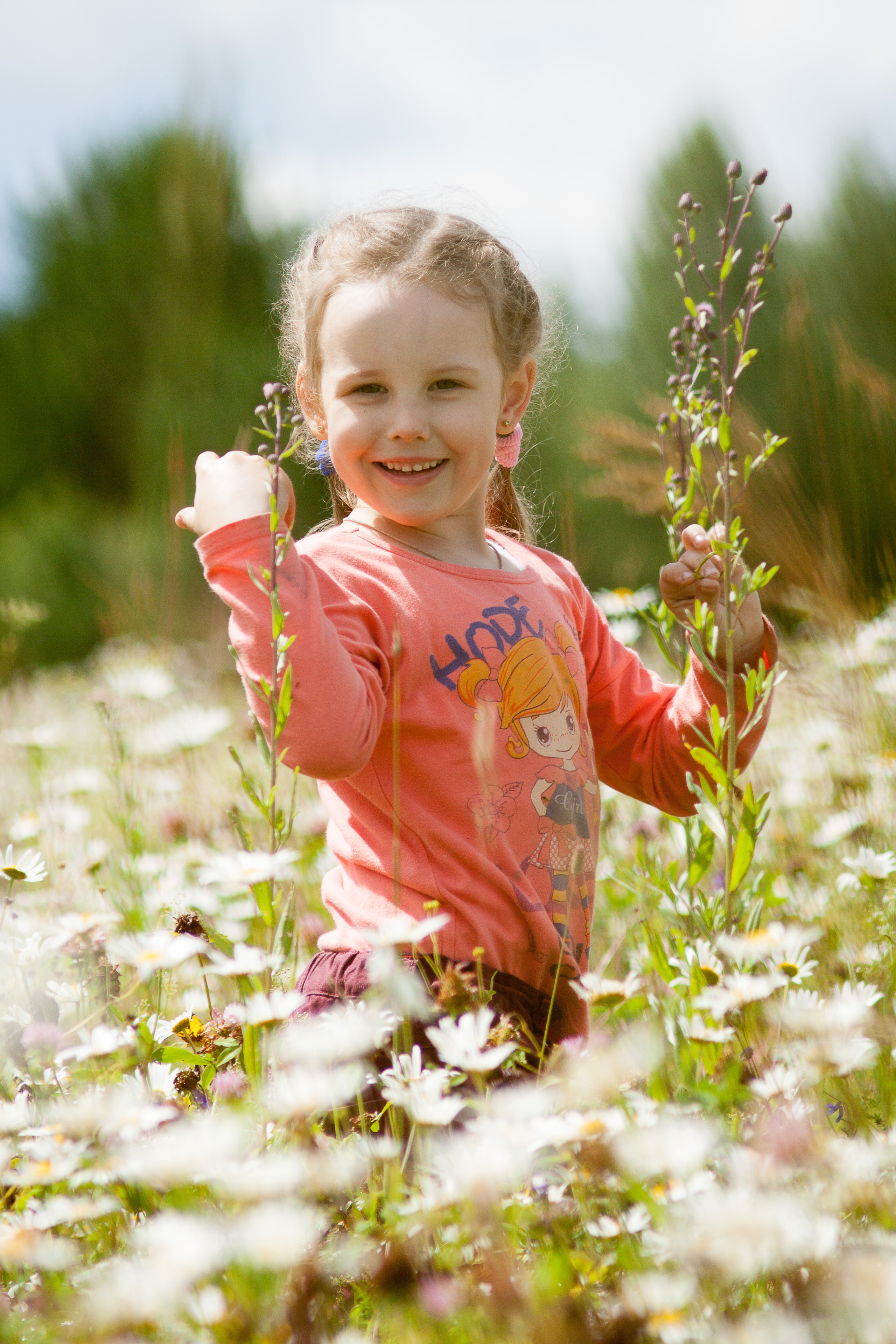 Девочка с русыми волосами в ромашковом поле.