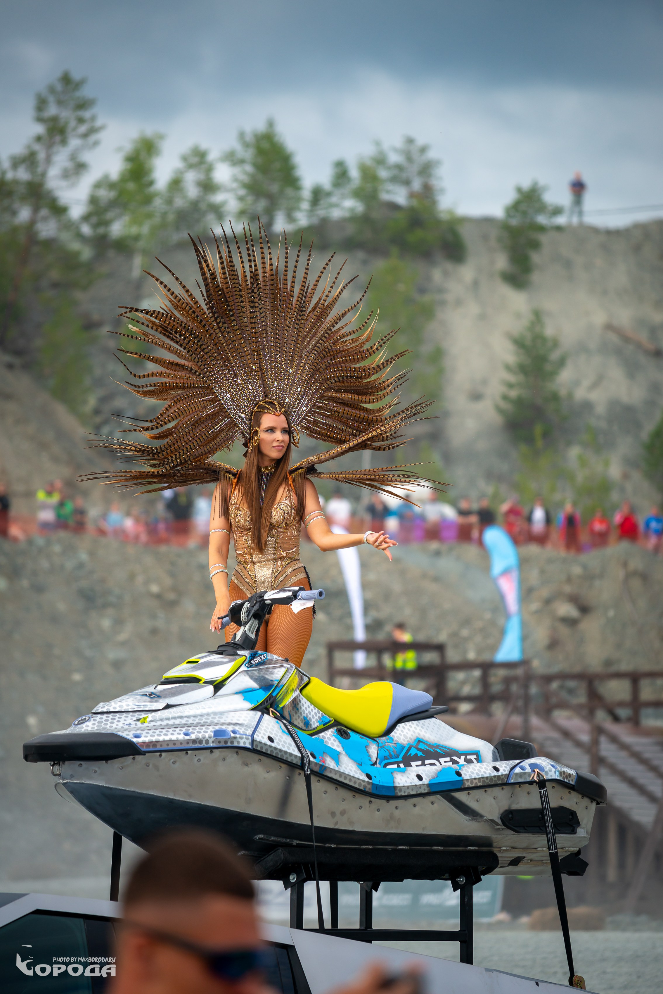 Эффектная модель в золотом наряде позирует на гидроцикле.