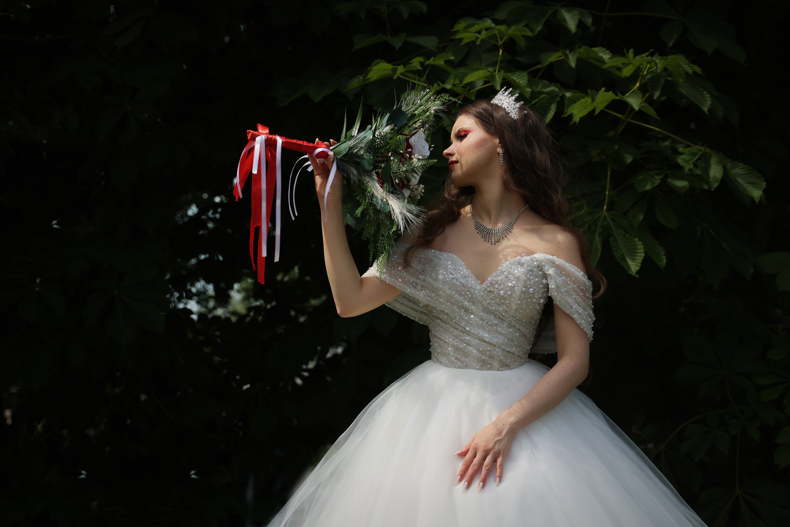 невеста смотрит на свадебный букет