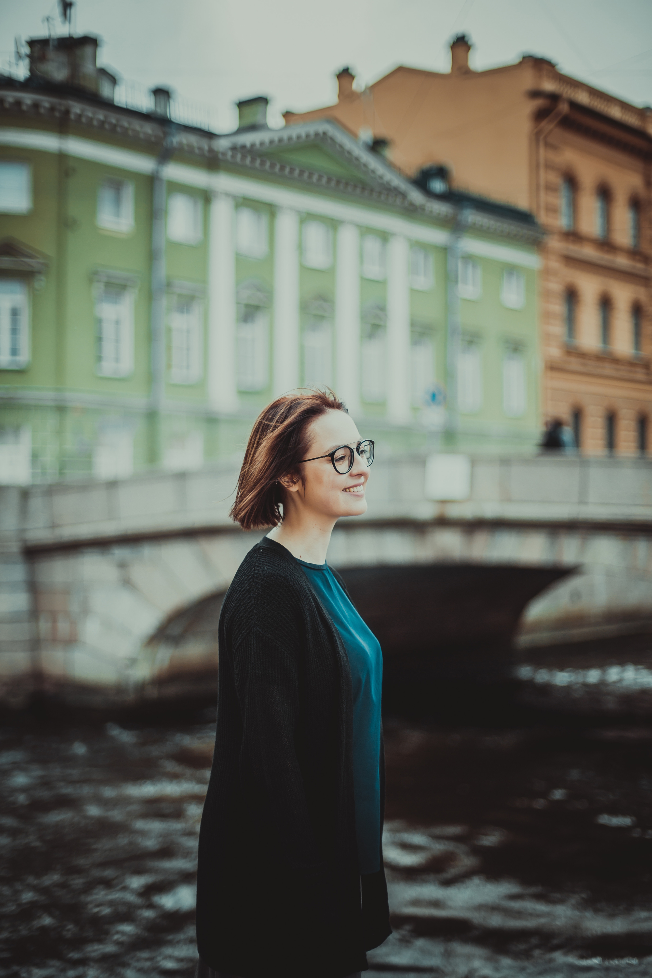 улыбающаяся девушка в очках на фоне моста