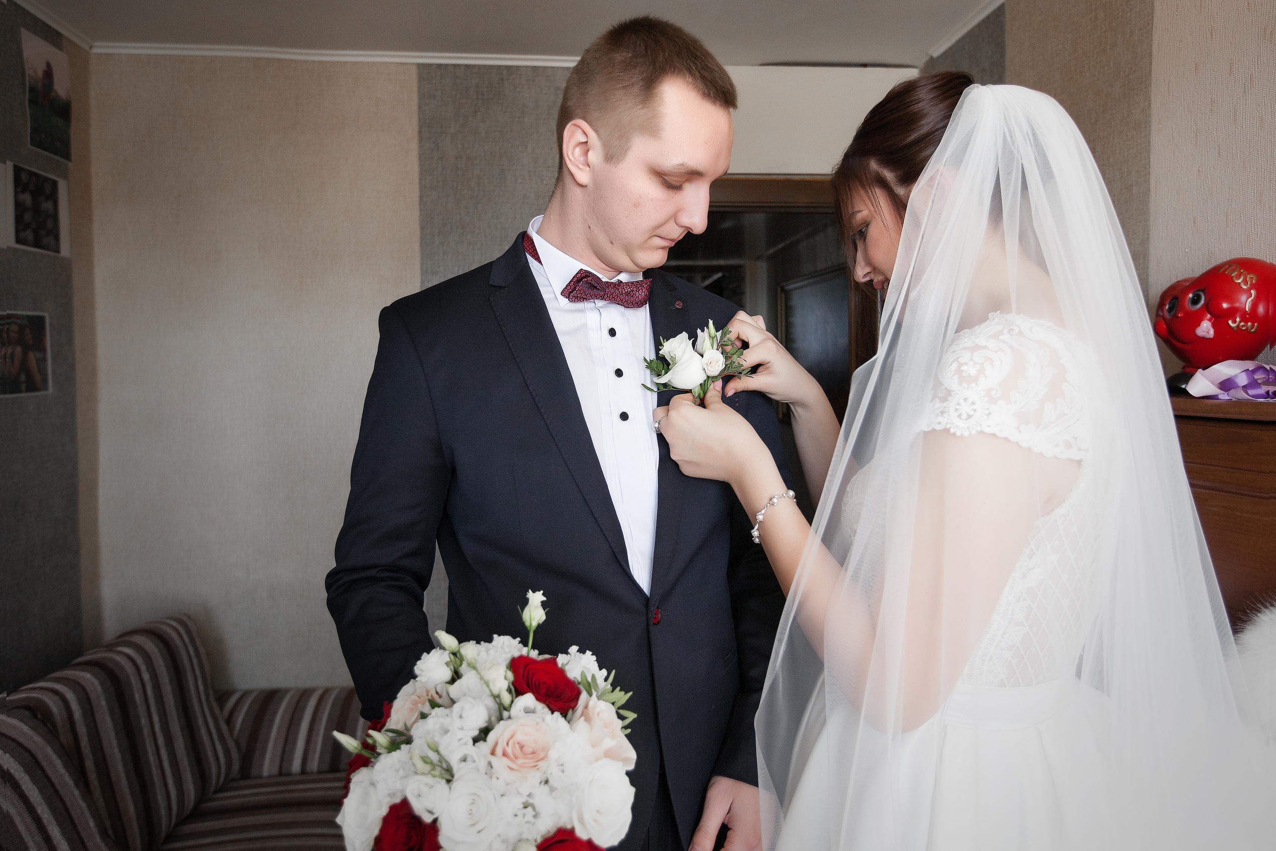 невеста одевает бутоньерку жениху
