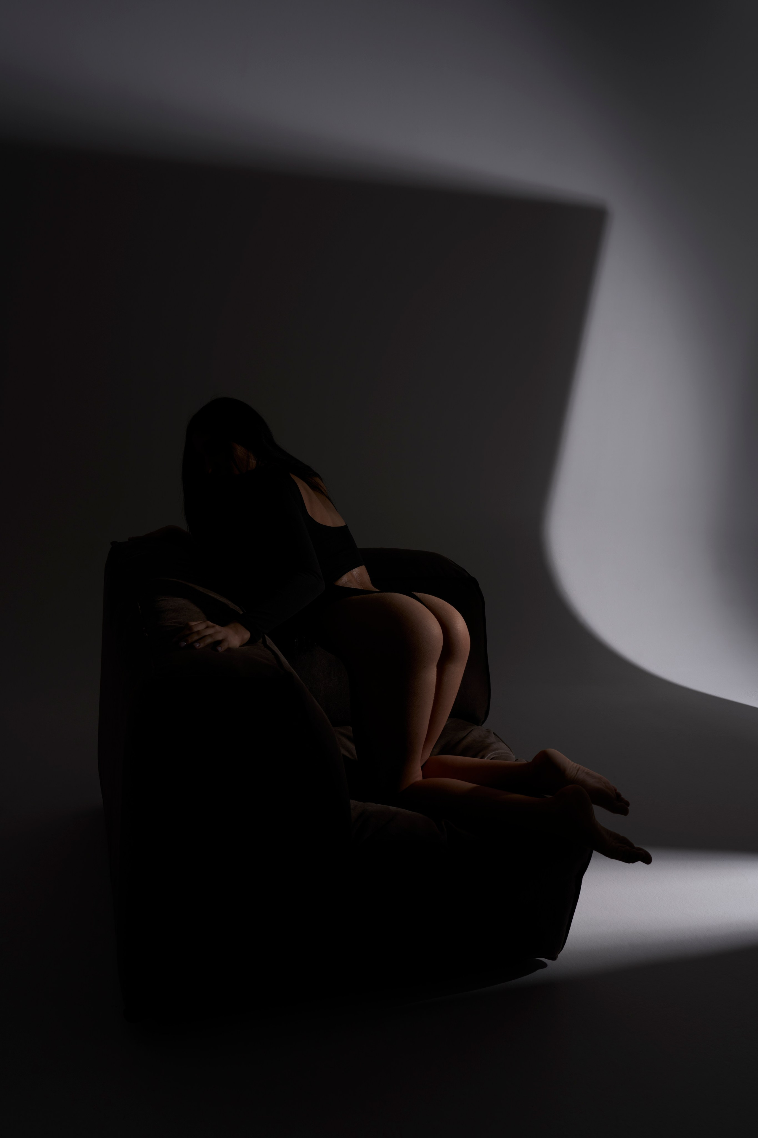 Эстетичная фотосессия в Москве: женская фигура в кресле, архитектура света и тени, студийная ню-съёмка